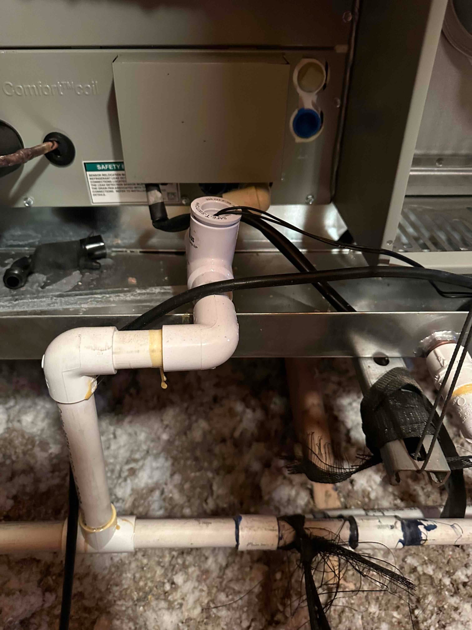 Condensate drain assembly with cleanout and trap connected to the bottom of the air handler in the attic.