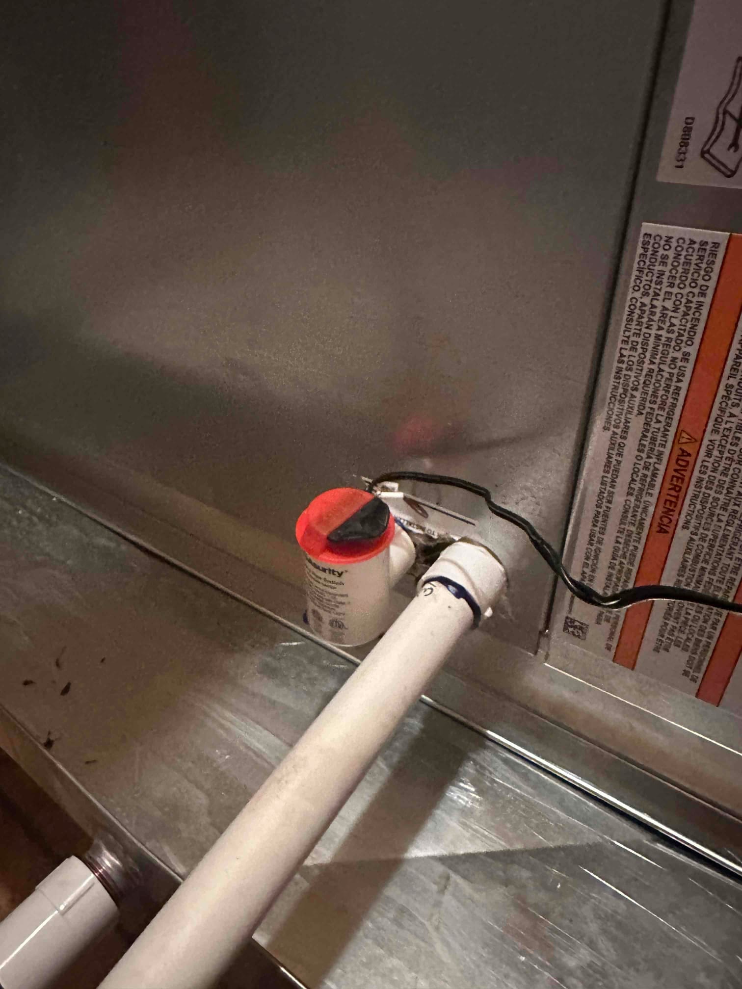 Condensate drain with inline safety float switch wired to the air handler, connected to PVC piping at the drain port.