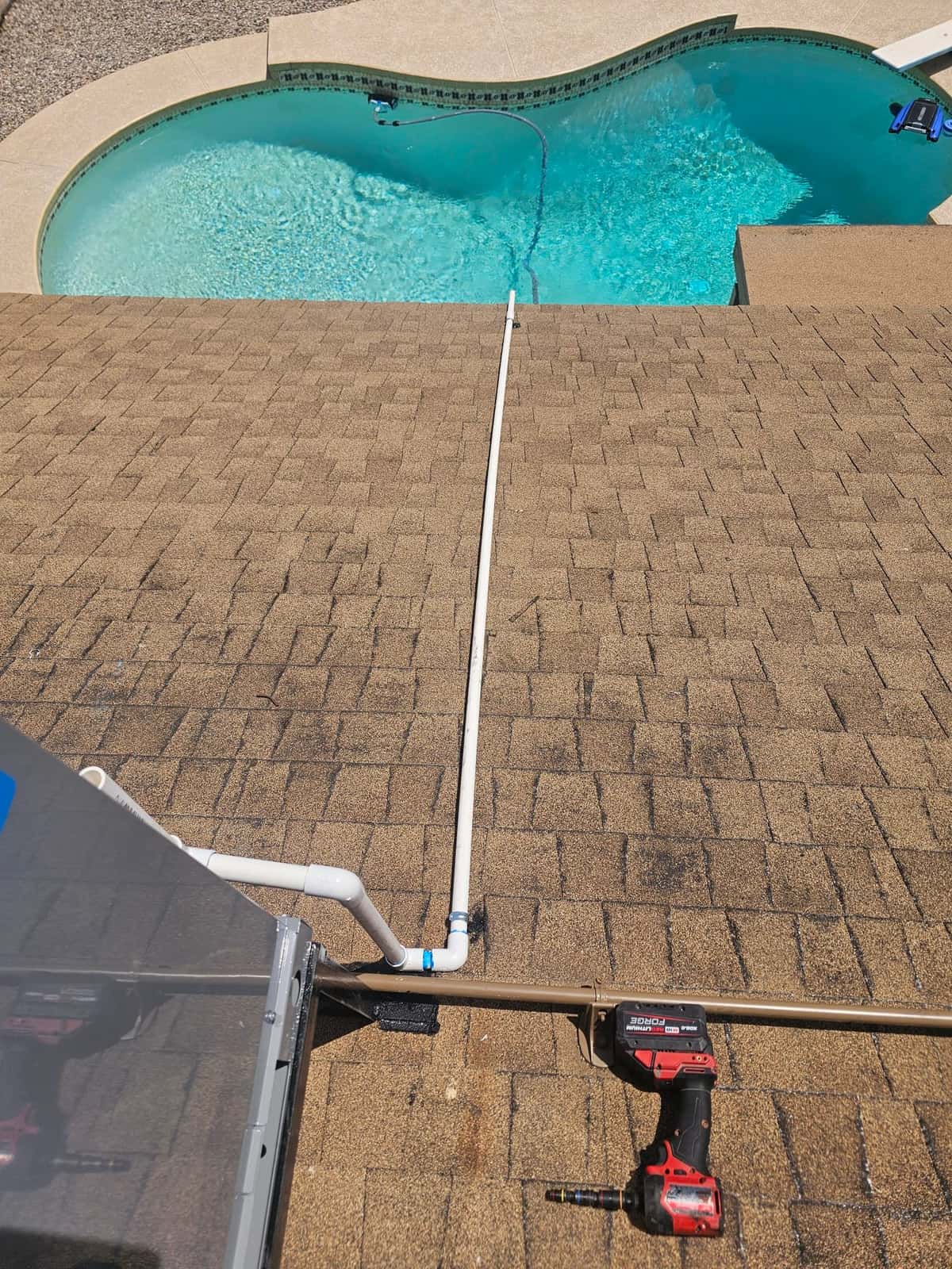 Condensate drain line routed across the roof from the rooftop unit, with sealed penetration and fittings visible near the unit.