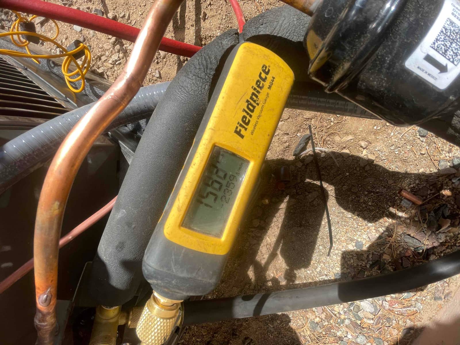 Digital micron gauge connected to the system shows a deep vacuum during evacuation before charging the new installation.