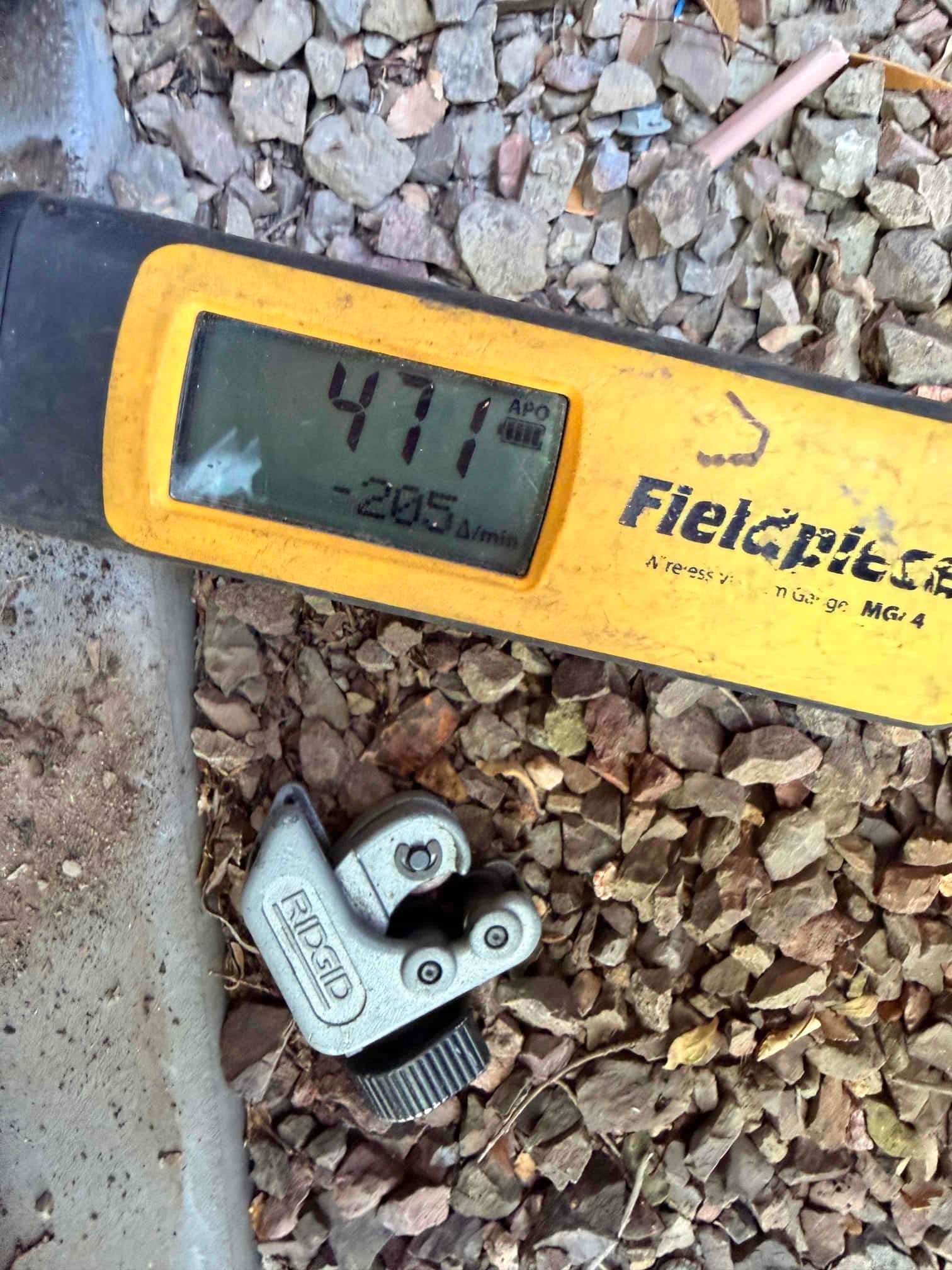 Digital micron gauge displays 471 microns during evacuation, confirming a deep vacuum before releasing refrigerant into the system.