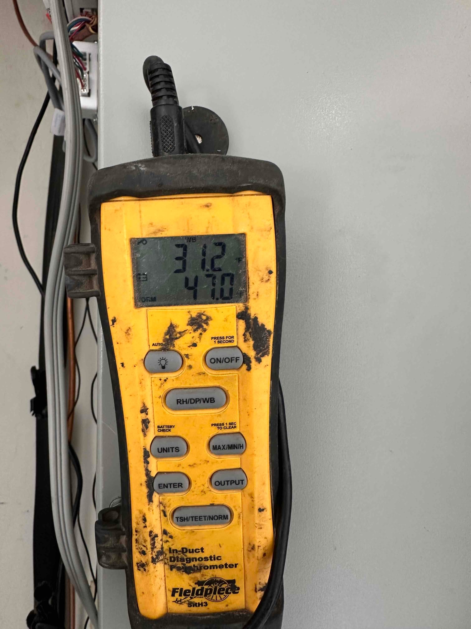 Digital thermometer displays 31.2°F and 47.0 on the screen during air-side measurements at the indoor unit.