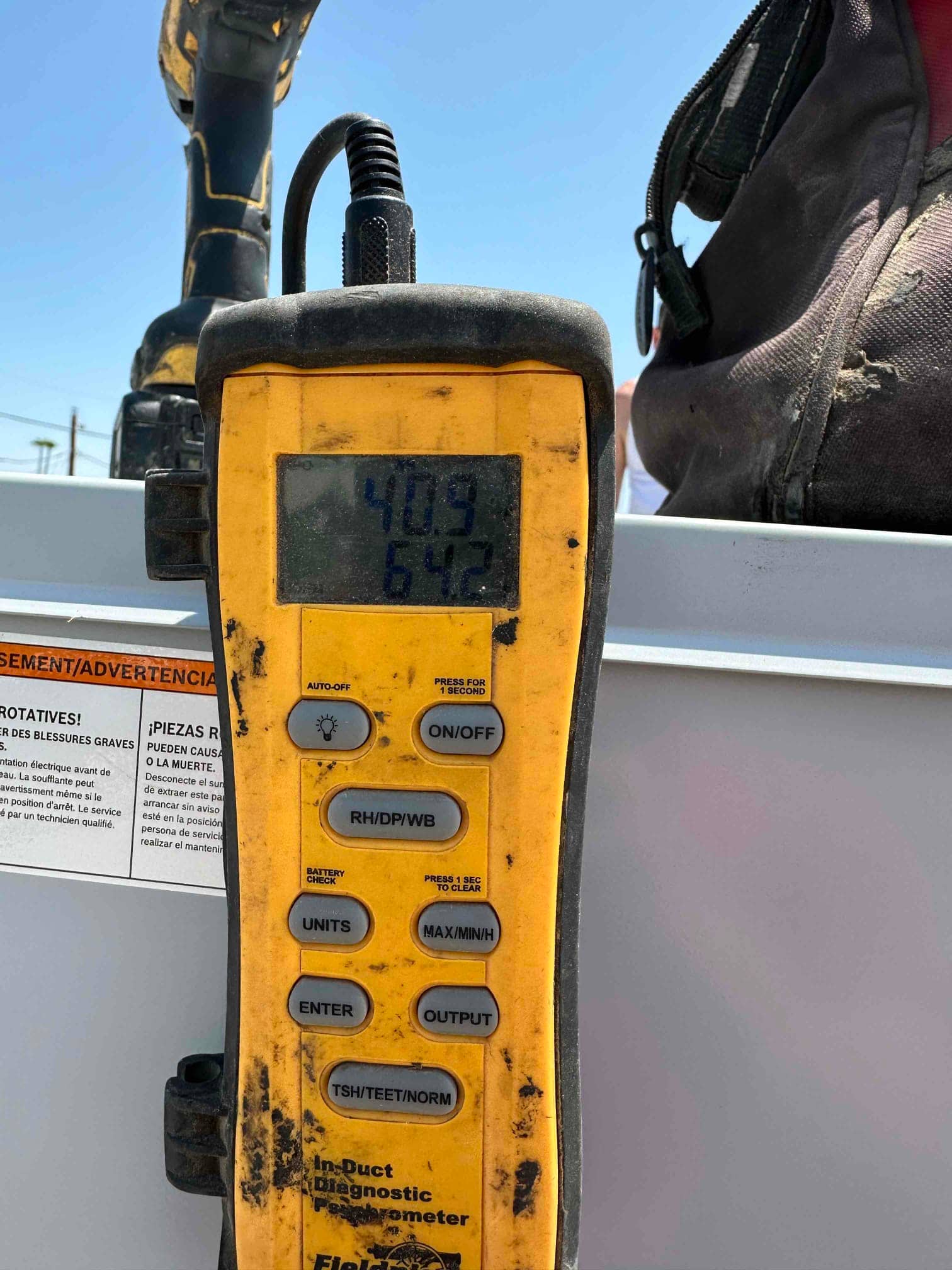 Digital thermometer displays 40.9 and 64.2 degrees Fahrenheit during air temperature checks on the newly installed system.