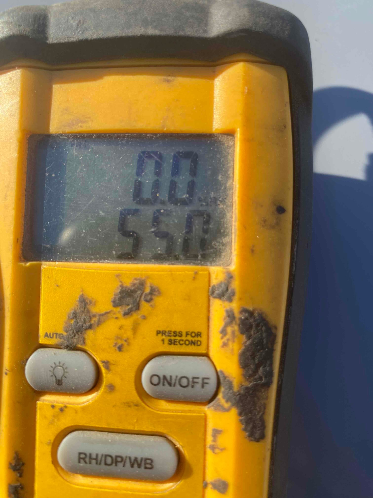 Digital thermometer displays 55.8 degrees Fahrenheit, documenting cooled supply air temperature at the outlet.