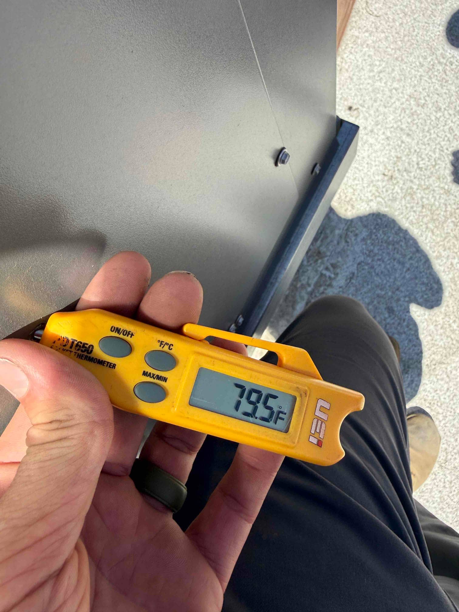 Digital thermometer displays 79.5°F during a return air temperature check on the newly installed system.