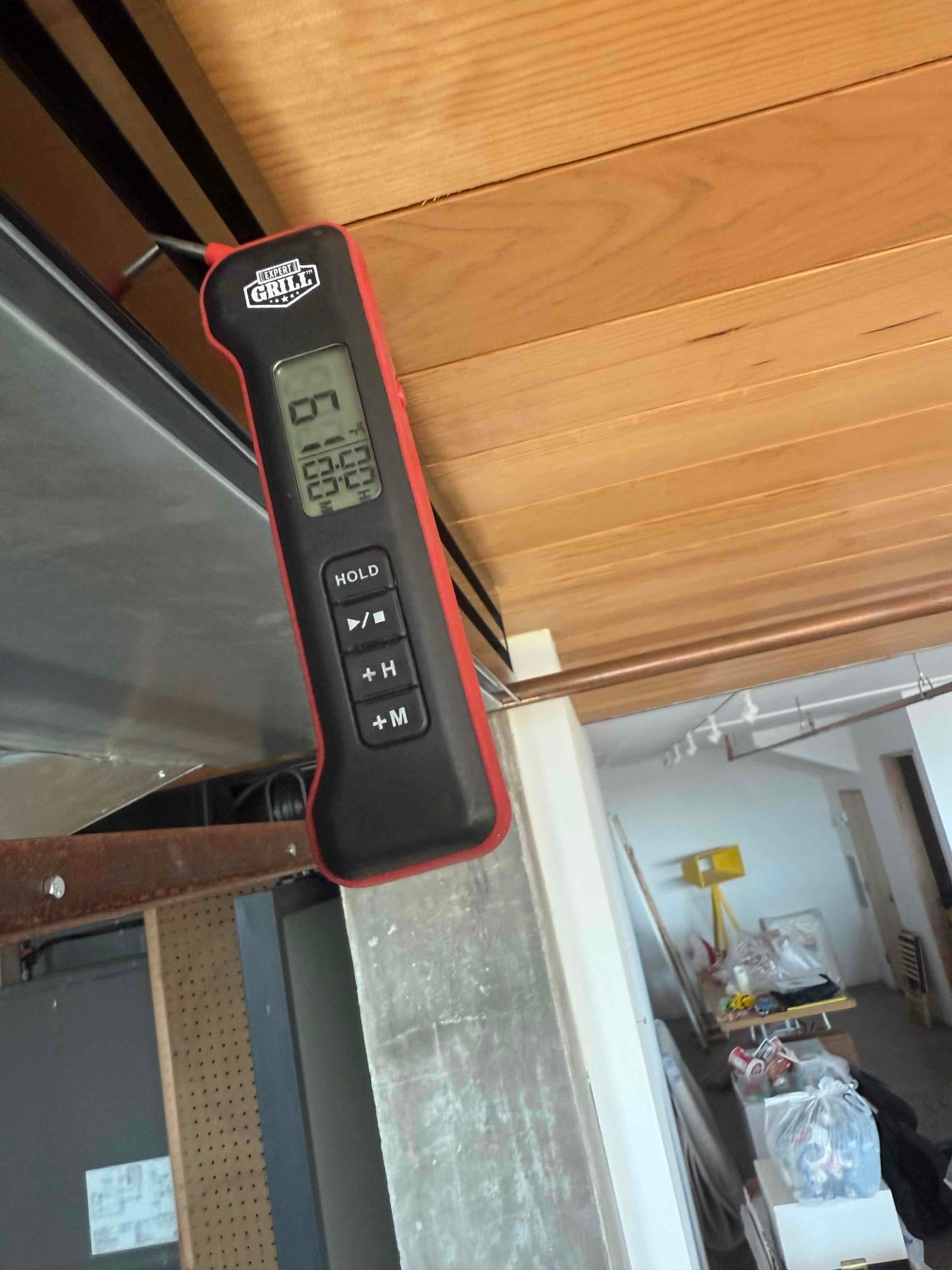 Digital thermometer measures 22.5 °C at a supply duct outlet during air conditioning service.