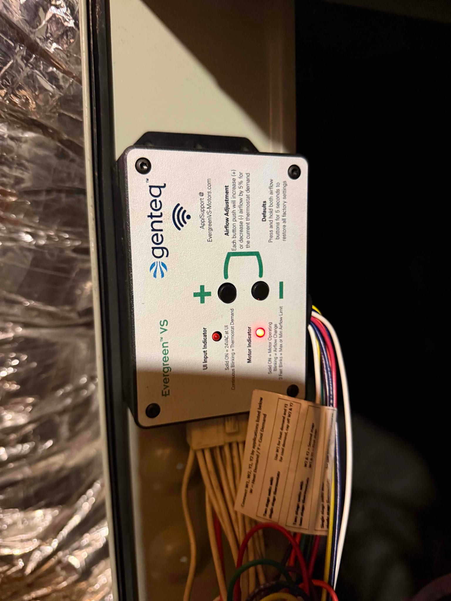 ECM blower motor control module installed in the air handler, with wiring harness connected and status LEDs illuminated.