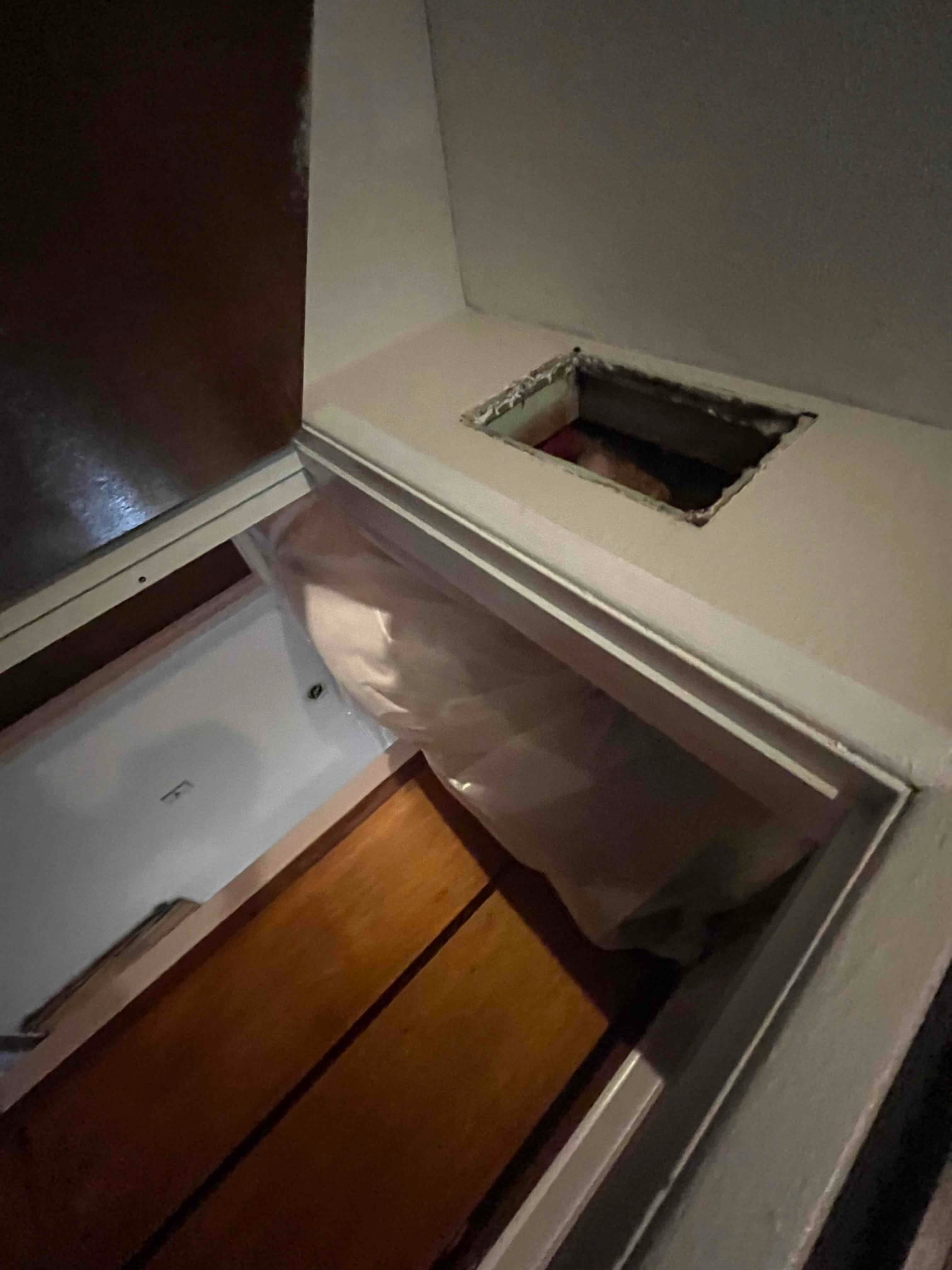 Framed ceiling opening and soffit area prepared for new supply duct connection during HVAC installation.