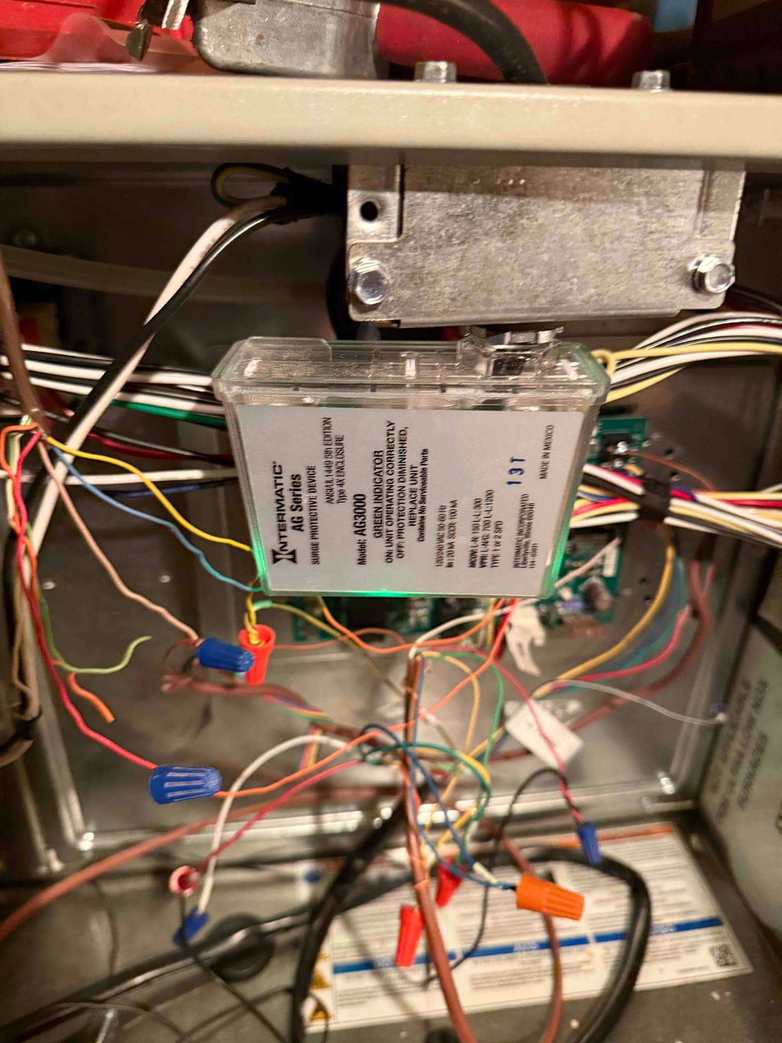 Furnace control compartment showing wiring connections with wire nuts and an installed control module mounted near the junction box.