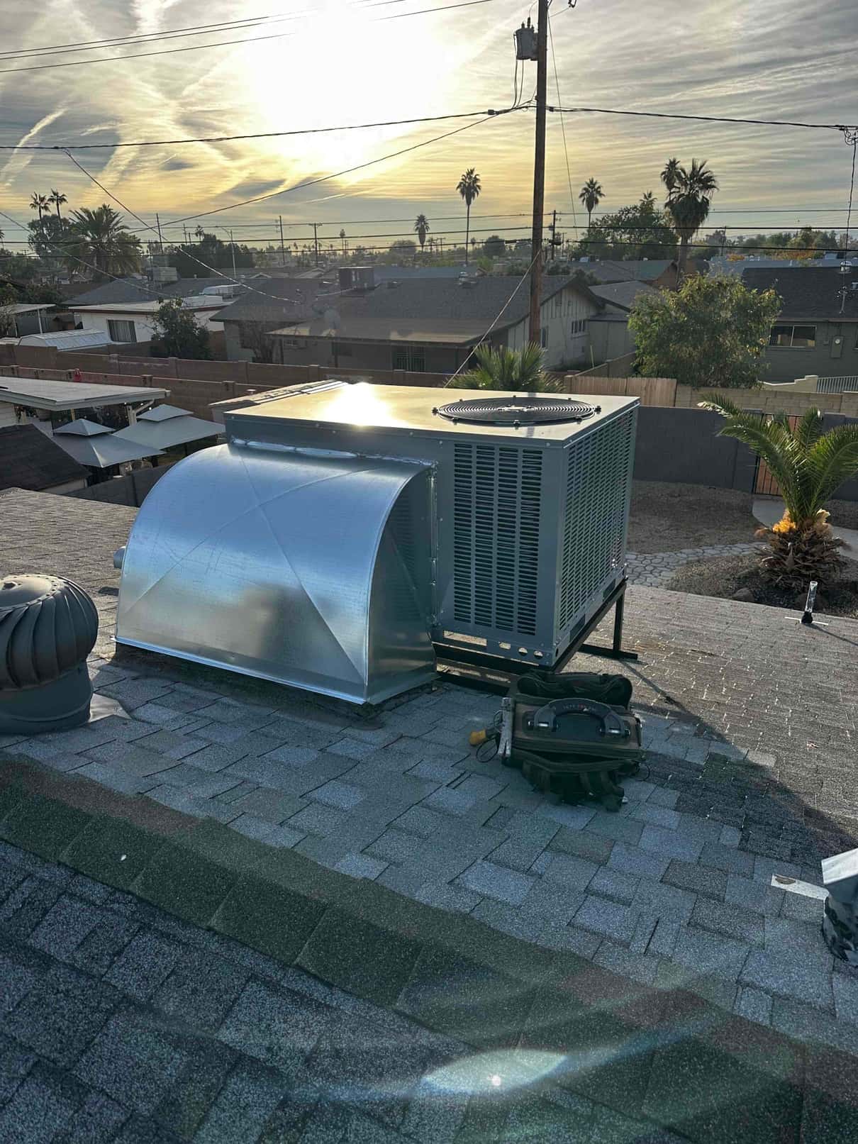 New rooftop package HVAC unit set on a metal stand with newly fabricated curb and duct transition in place.