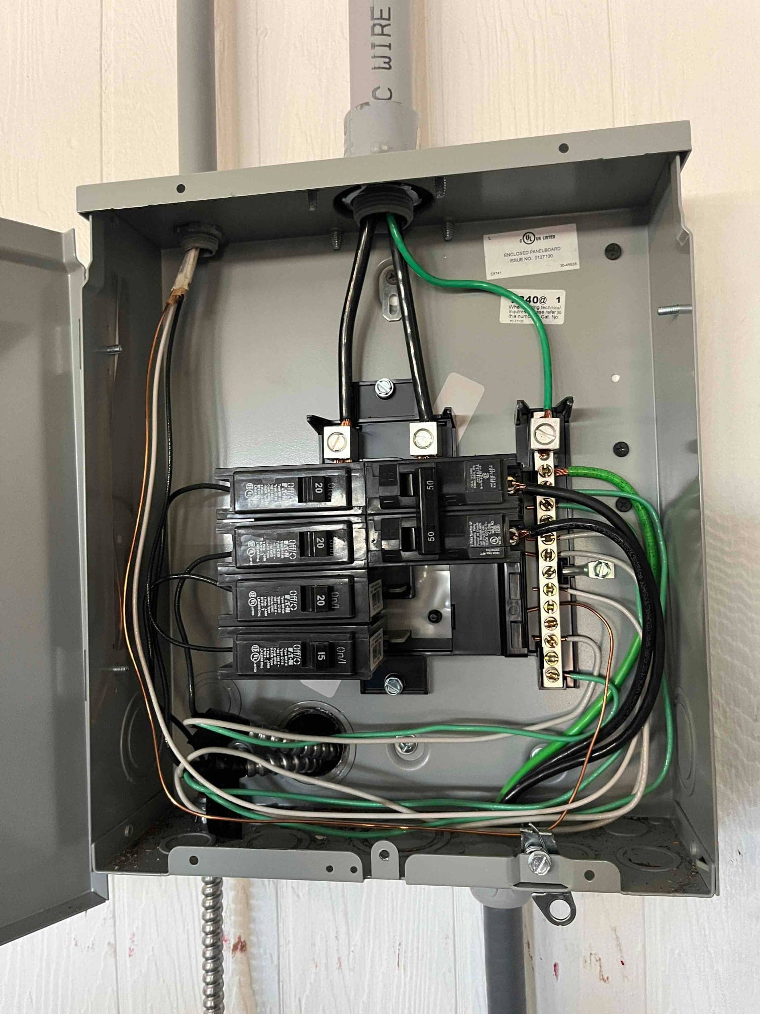 Open electrical panel shows breakers, neutral and ground bars, and connected wiring for HVAC circuit service.