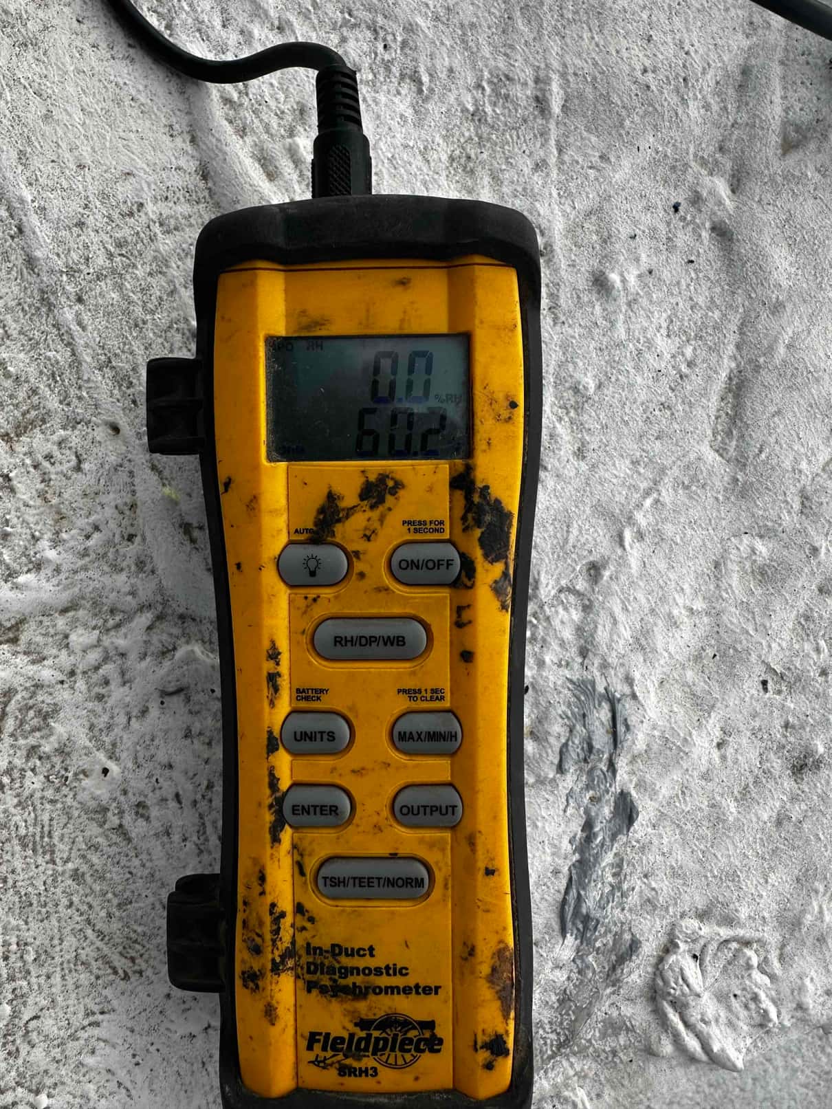 Digital probe thermometer shows 60.2 degrees Fahrenheit, documenting supply air temperature during system commissioning.