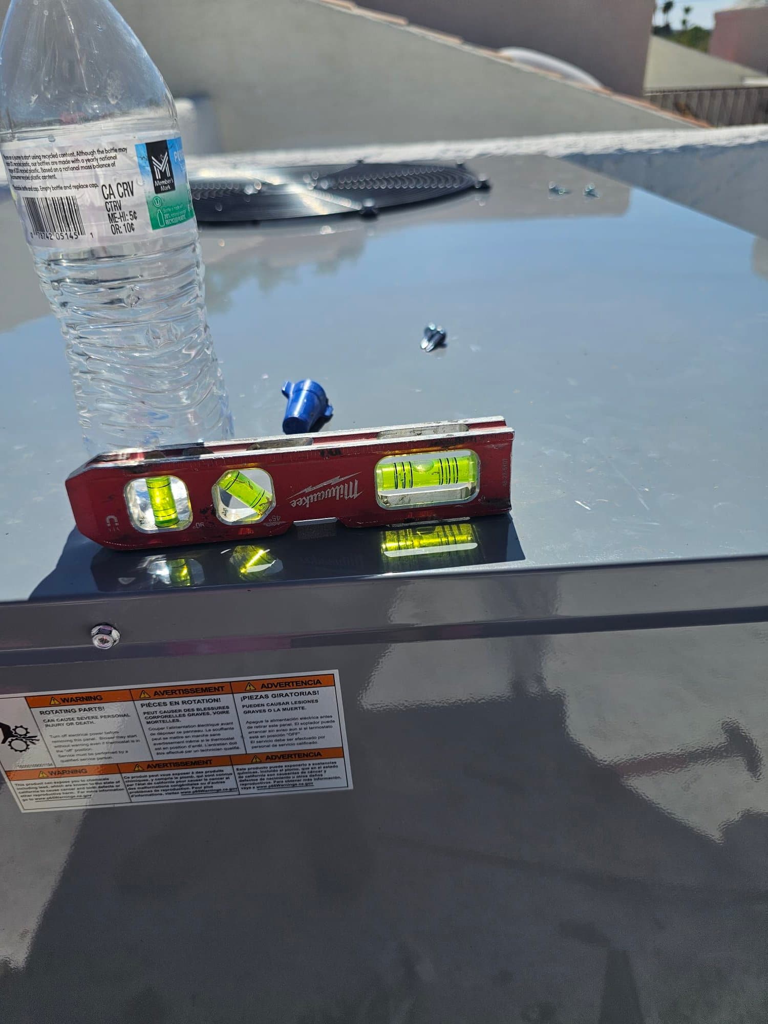 Level placed on top of a newly installed rooftop package unit, confirming the cabinet sits square and properly aligned.