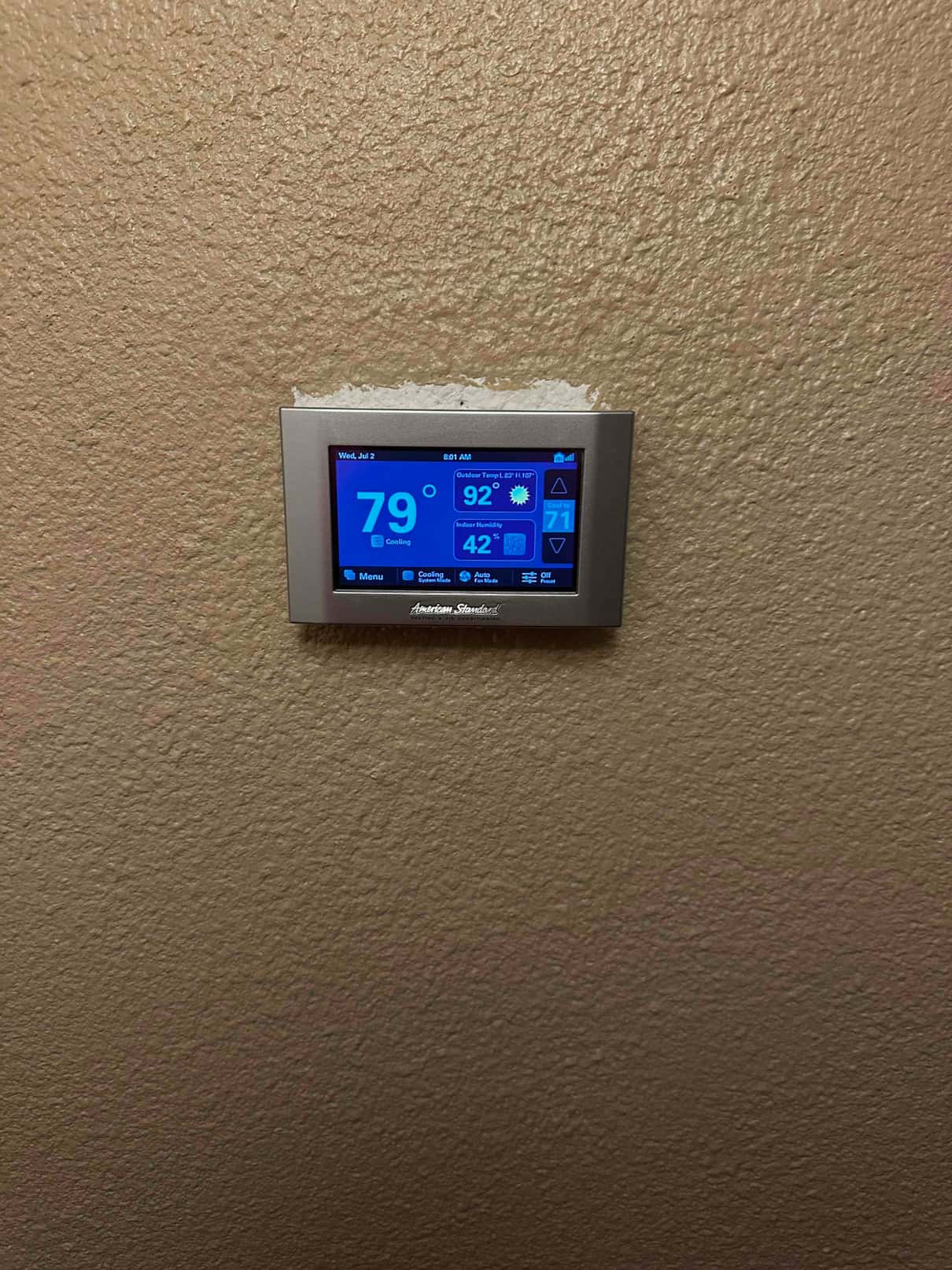 Wall-mounted touchscreen thermostat operating in cooling mode, display showing indoor temperature of 79 degrees and system status.
