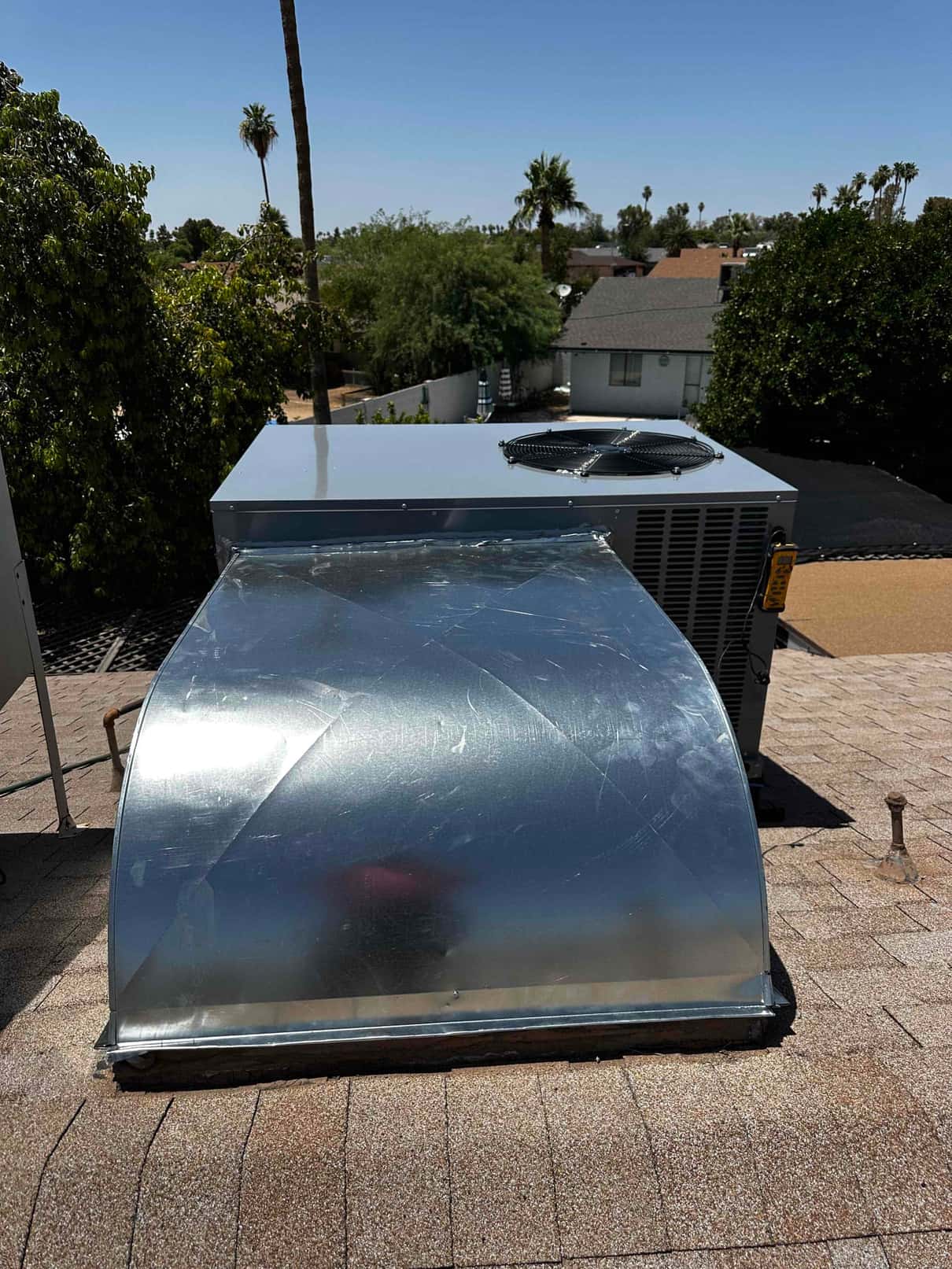 Rooftop package HVAC unit with newly fabricated curb adapter and sealed roof penetration set on shingle roof.