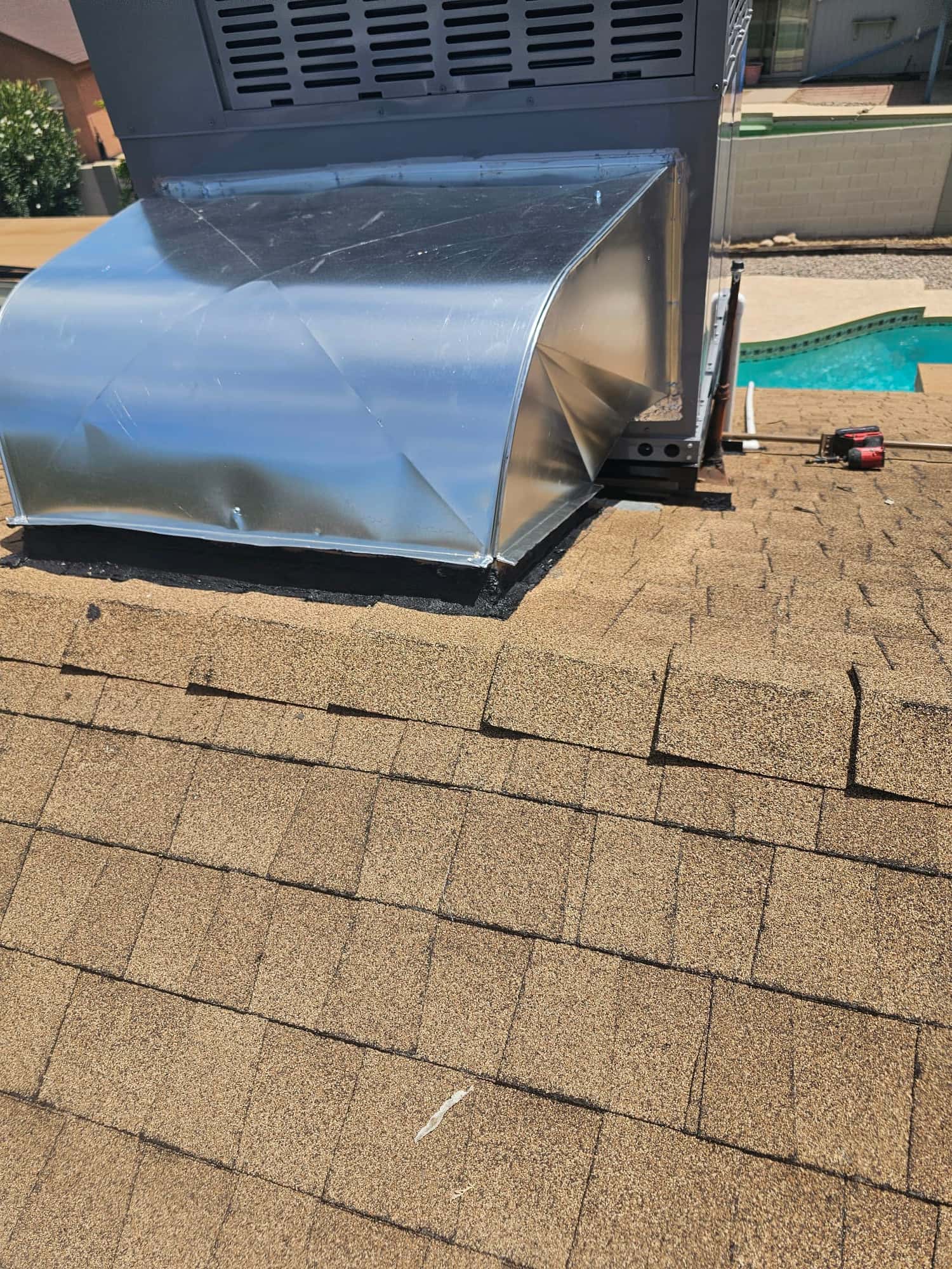 Rooftop packaged unit with newly fabricated sheet-metal transition duct set and sealed at the roof curb.