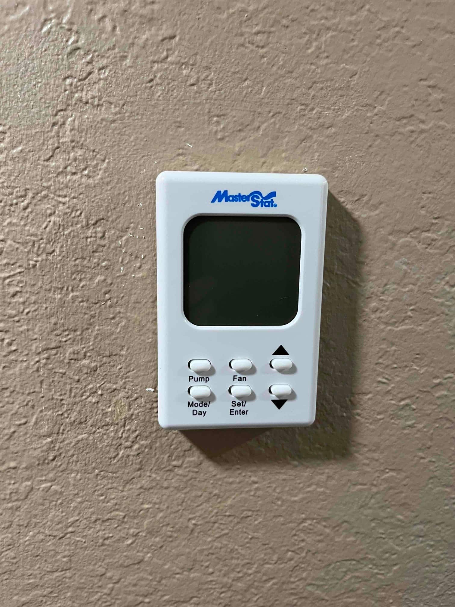 Wall-mounted controller for an evaporative cooler with buttons for pump, fan, mode/day, and set/enter.