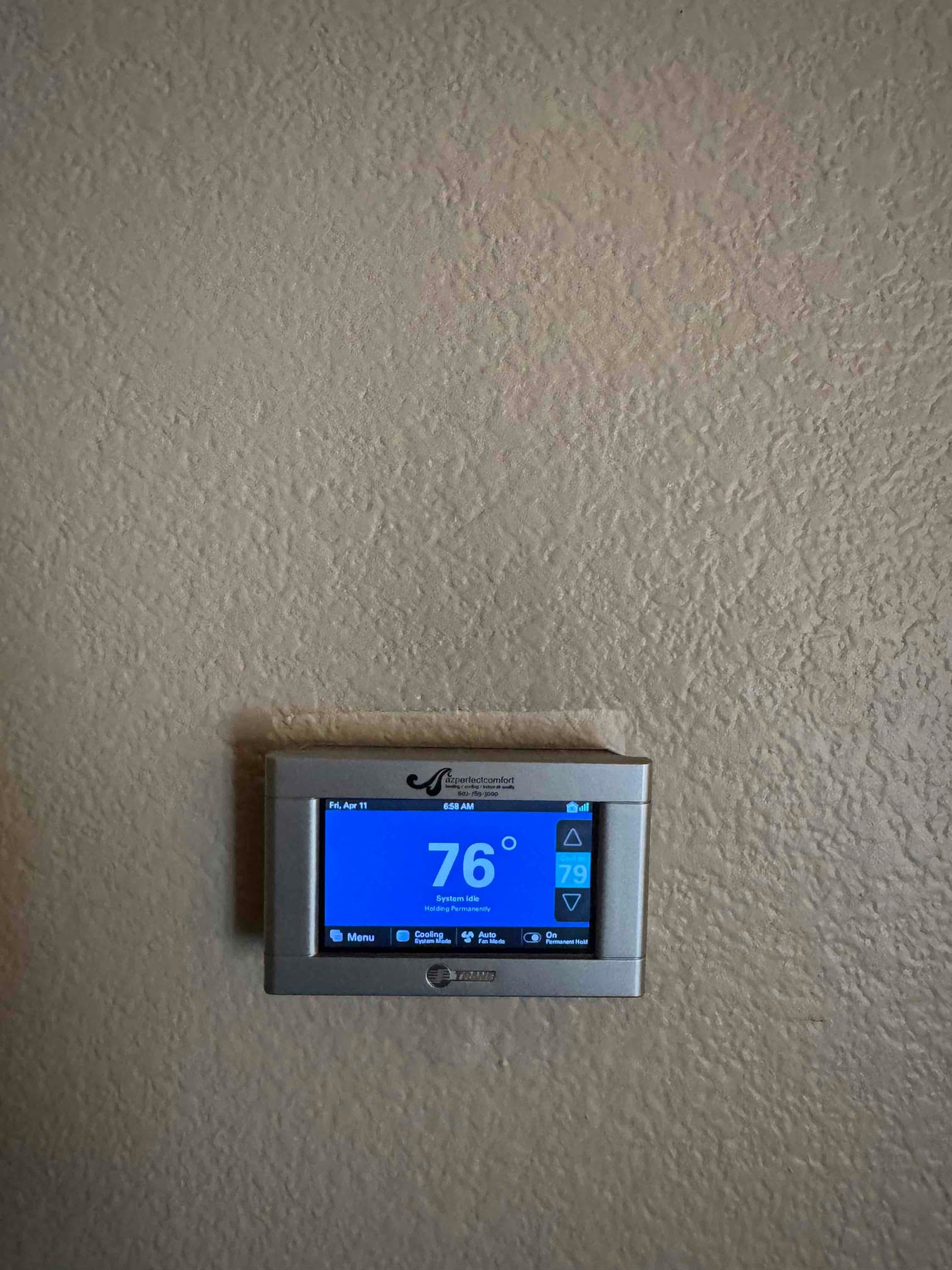 Wall-mounted digital thermostat displays indoor temperature of 76°F with cooling setpoint at 79°F and active cooling mode.