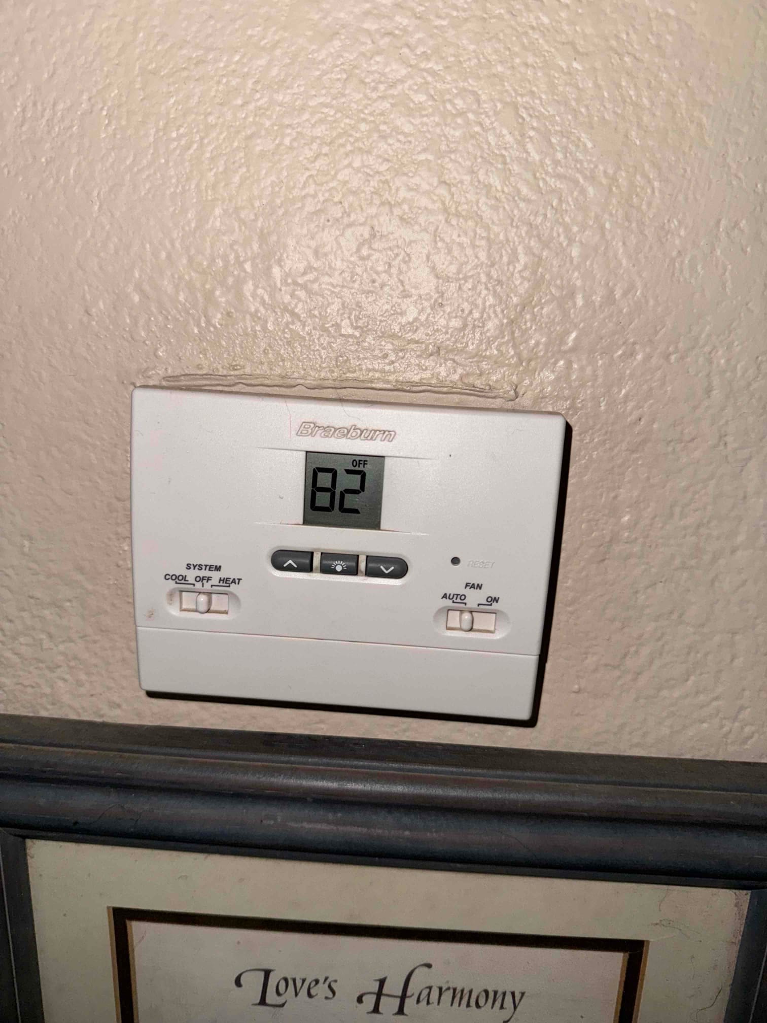 Wall-mounted digital thermostat shows 80°F with system set to off and fan in auto mode.