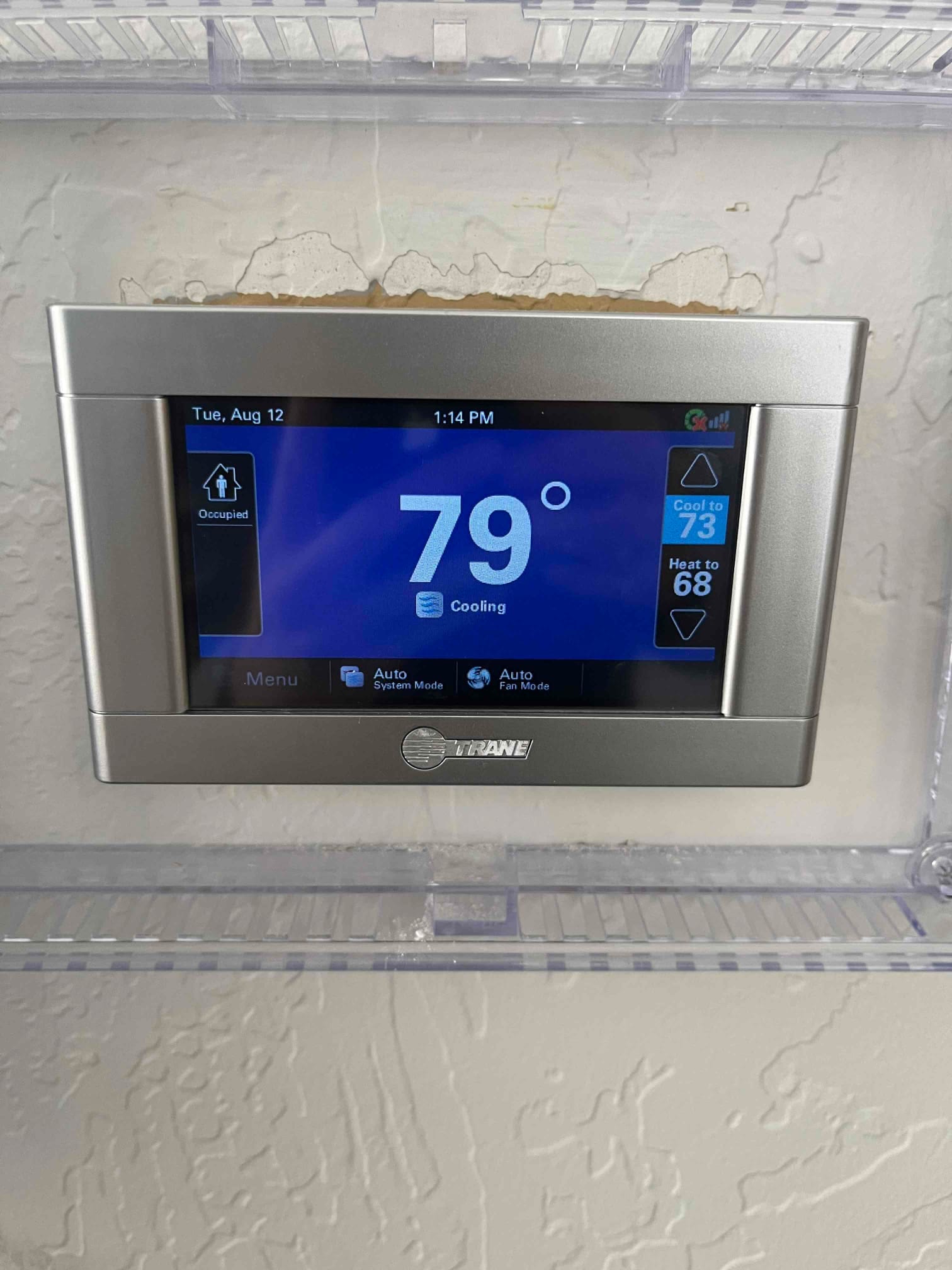Wall-mounted thermostat display shows indoor temperature at 79°F with system set to Cooling mode.
