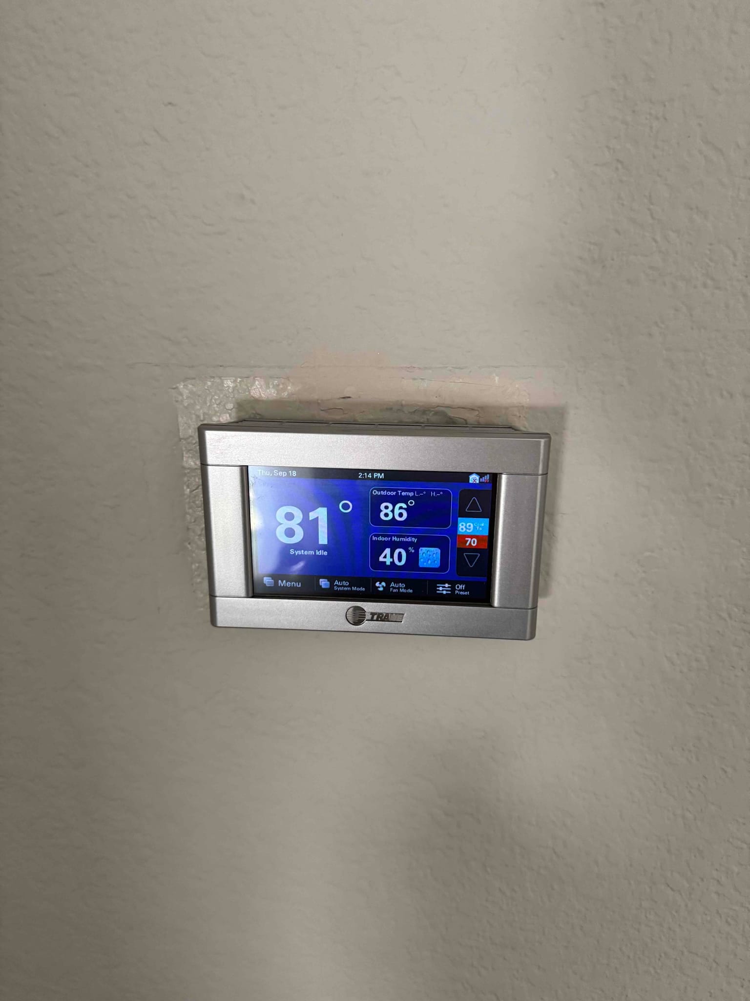 Wall-mounted thermostat display shows indoor temperature at 81°F with cooling setpoint at 70°F and system status icons.