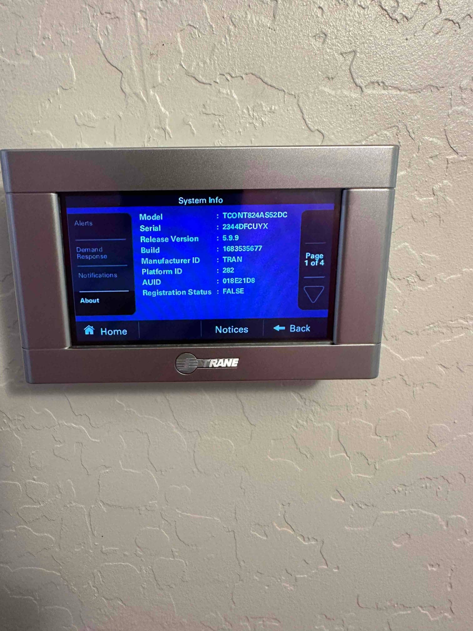 Wall-mounted touchscreen thermostat displays system information menu during setup after the new HVAC installation.