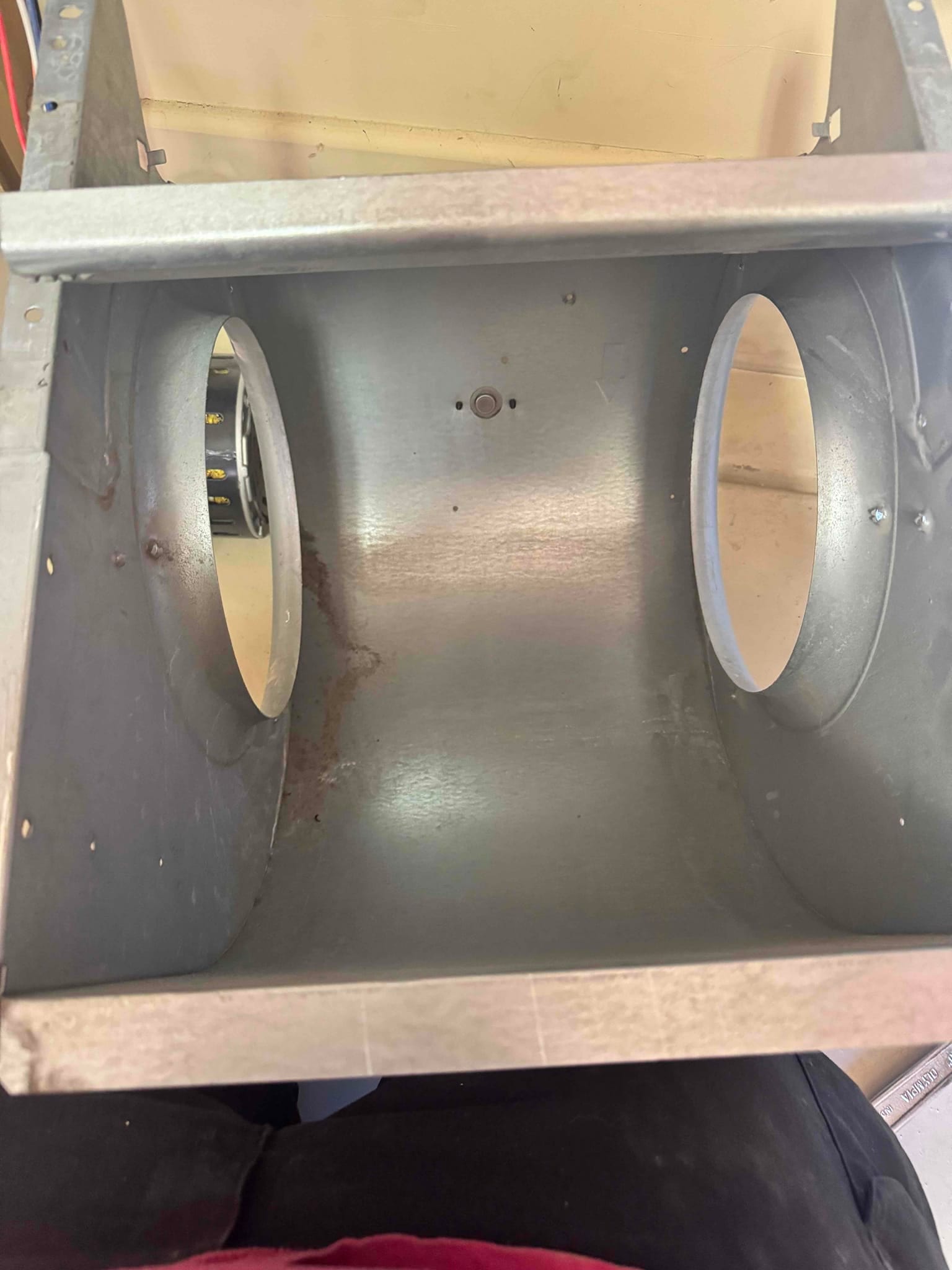 Cleaned blower housing interior showing dust residue and surface rust near the mounting area before reinstallation.