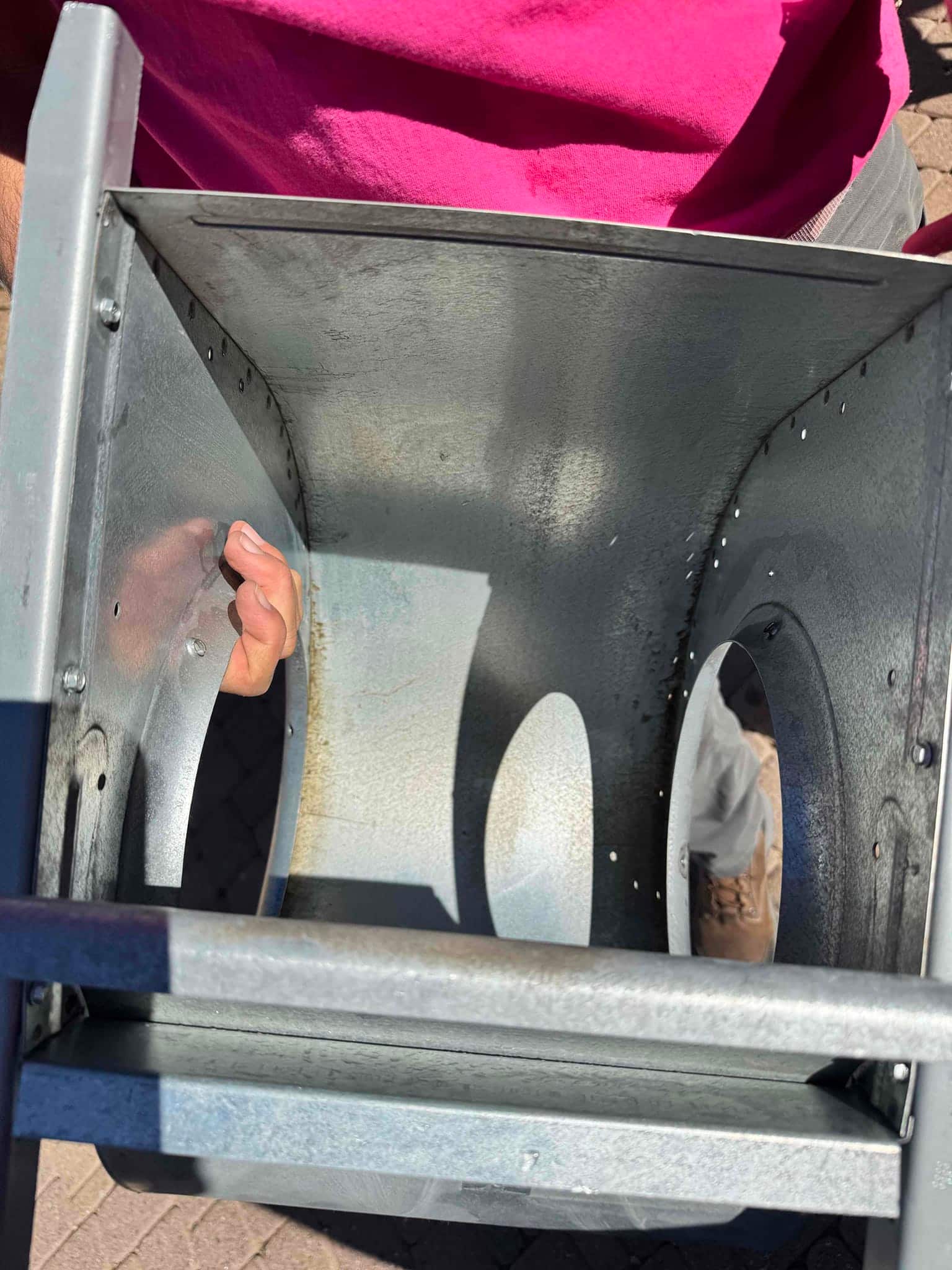Cleaned blower housing removed from the air handler, showing smooth interior surfaces and reassembly fasteners along the side seams.