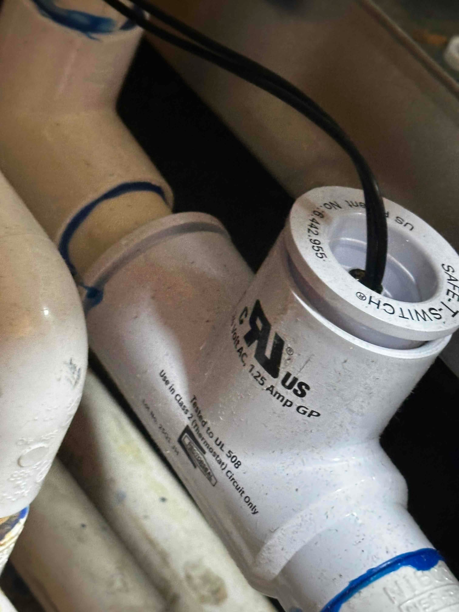 Condensate drain assembly with an inline safety float switch installed and wired to protect against overflow during cooling operation.