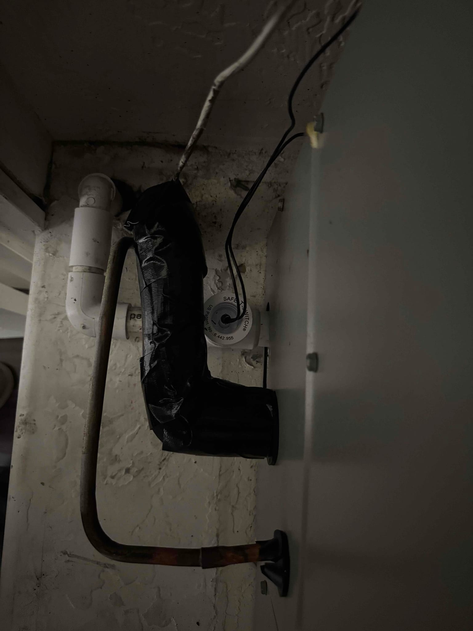 Condensate drain and PVC trap connected to the air handler cabinet, with insulated suction line and brazed copper line set penetration.