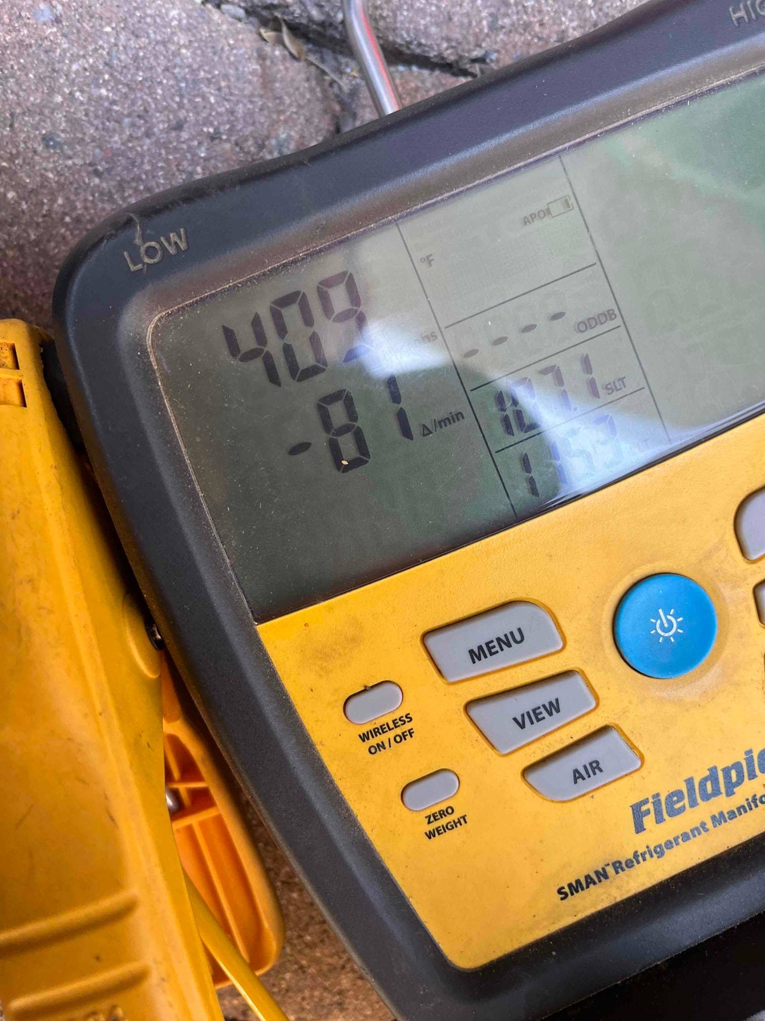 Digital manifold gauge displays 409 PSI on the low side during a nitrogen pressure test of the new system.