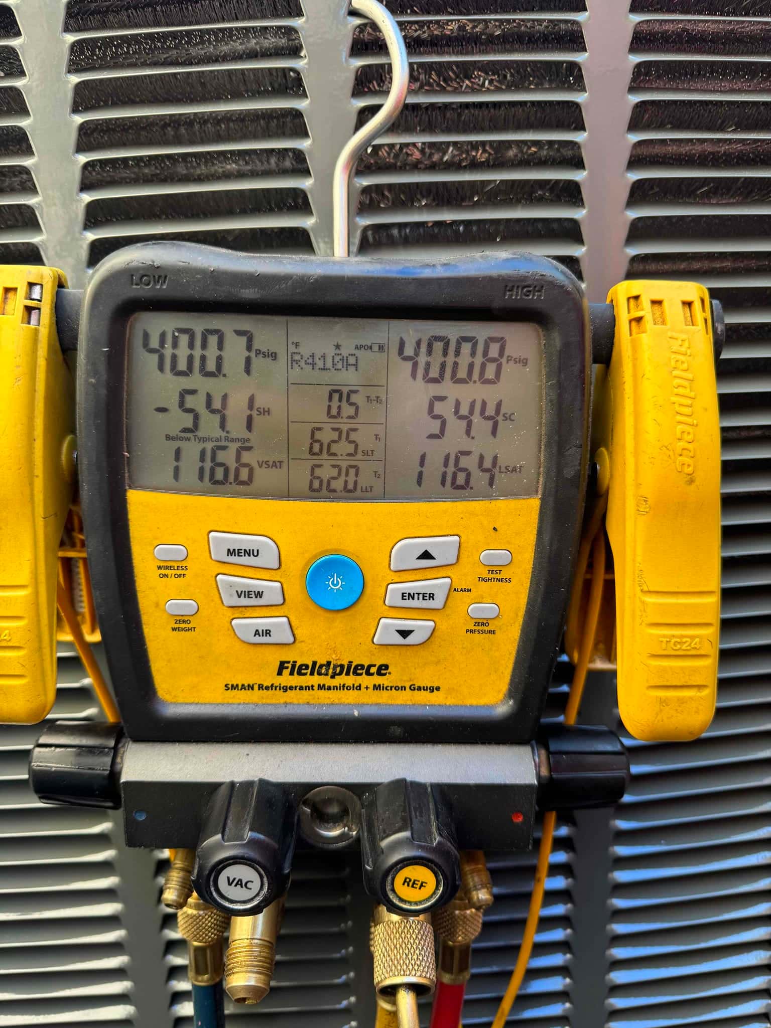 Digital manifold gauges hold about 400 PSI on both low and high sides during a nitrogen pressure test at the outdoor unit.