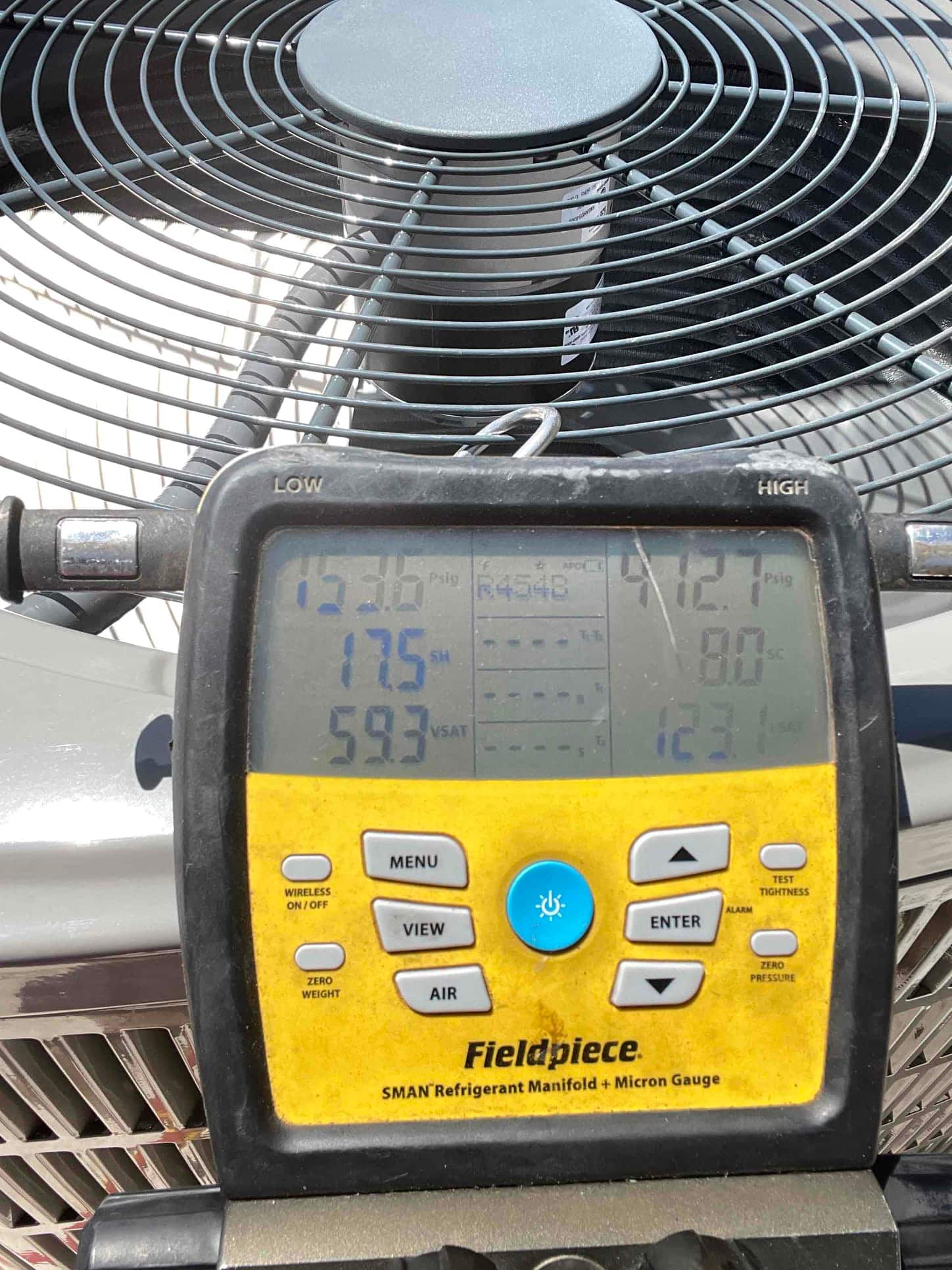 Digital manifold on the outdoor unit shows operating pressures with R‑454B selected during system commissioning.