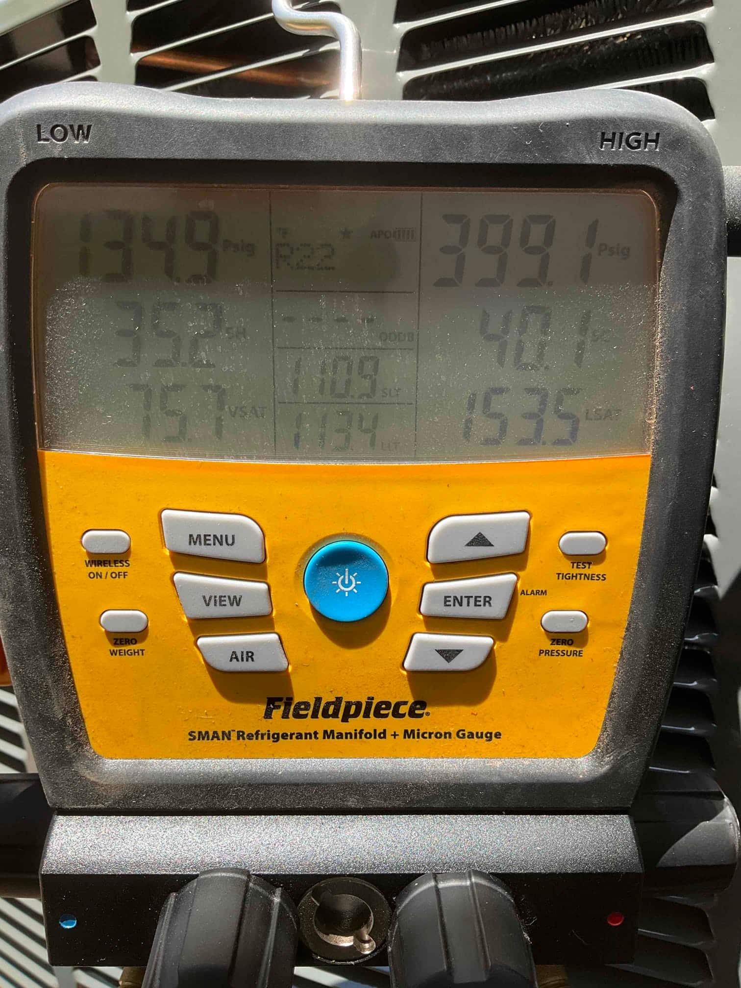 Digital manifold shows operating pressures while the air conditioner runs, with distinct low and high side PSI readings displayed on screen.