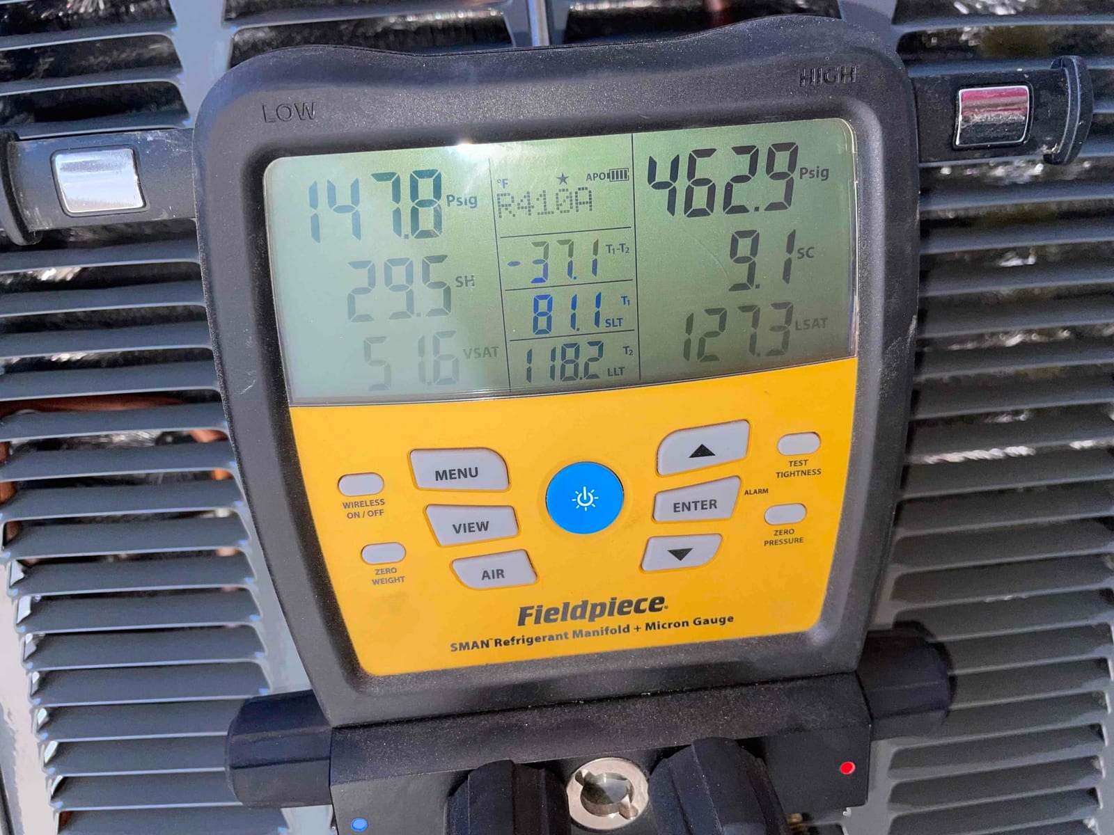 Digital manifold shows system operating with low side 148 PSIG and high side 463 PSIG while commissioning the new air conditioner.
