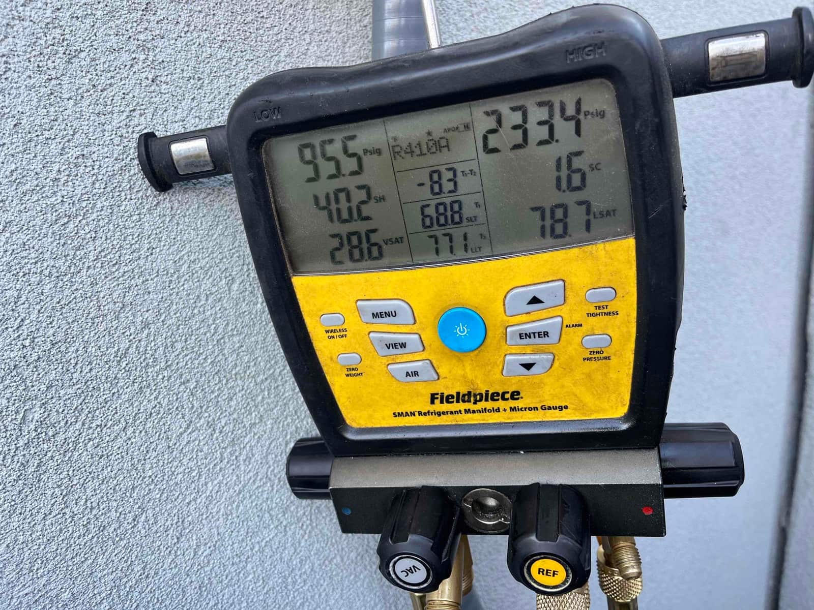 Digital manifold shows system operating with low side at 95.5 PSI and high side at 233.4 PSI on R‑410A refrigerant.