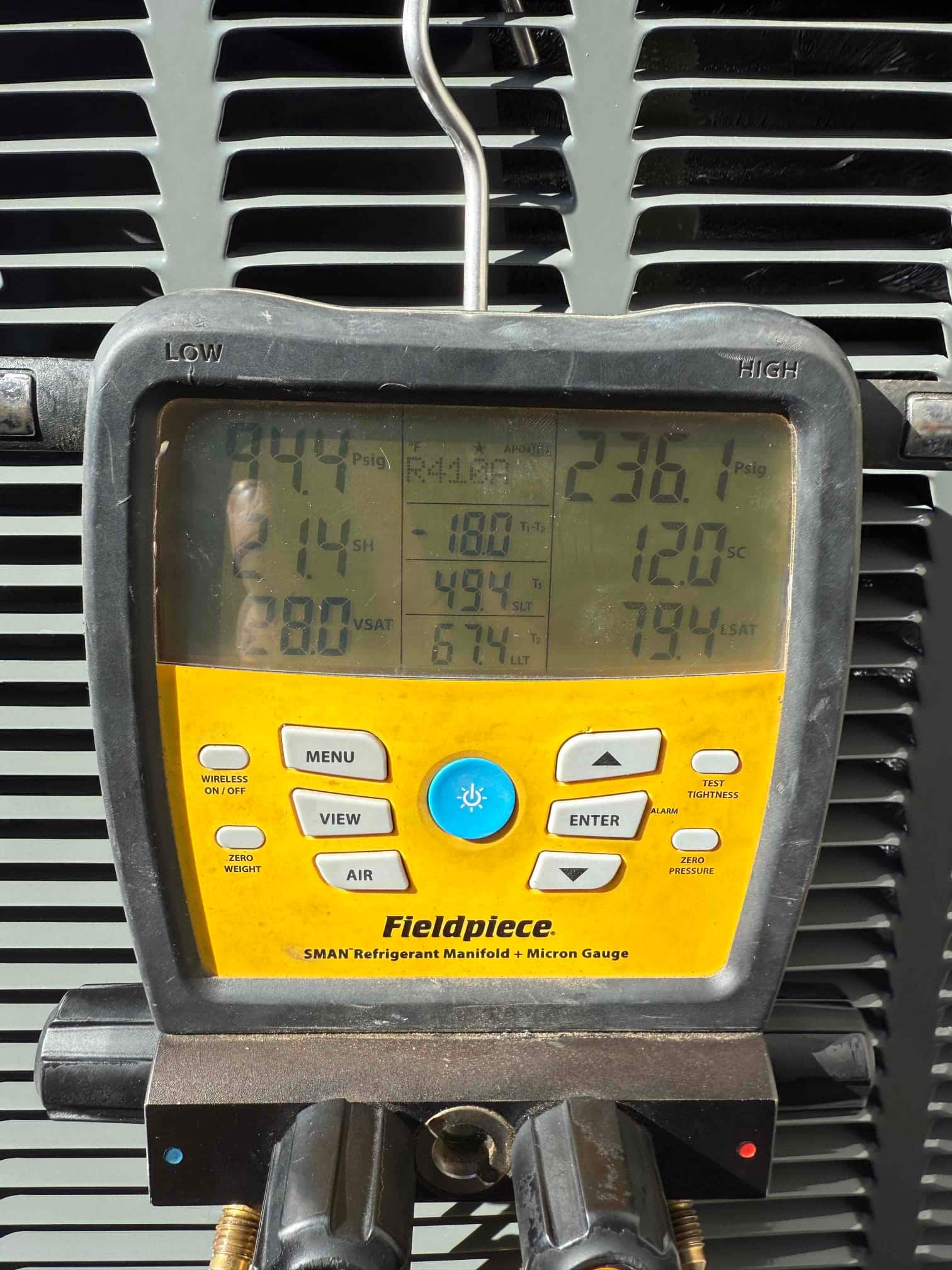 Digital manifold shows system operating pressures with low side at 94 psig and high side at 236 psig during commissioning.
