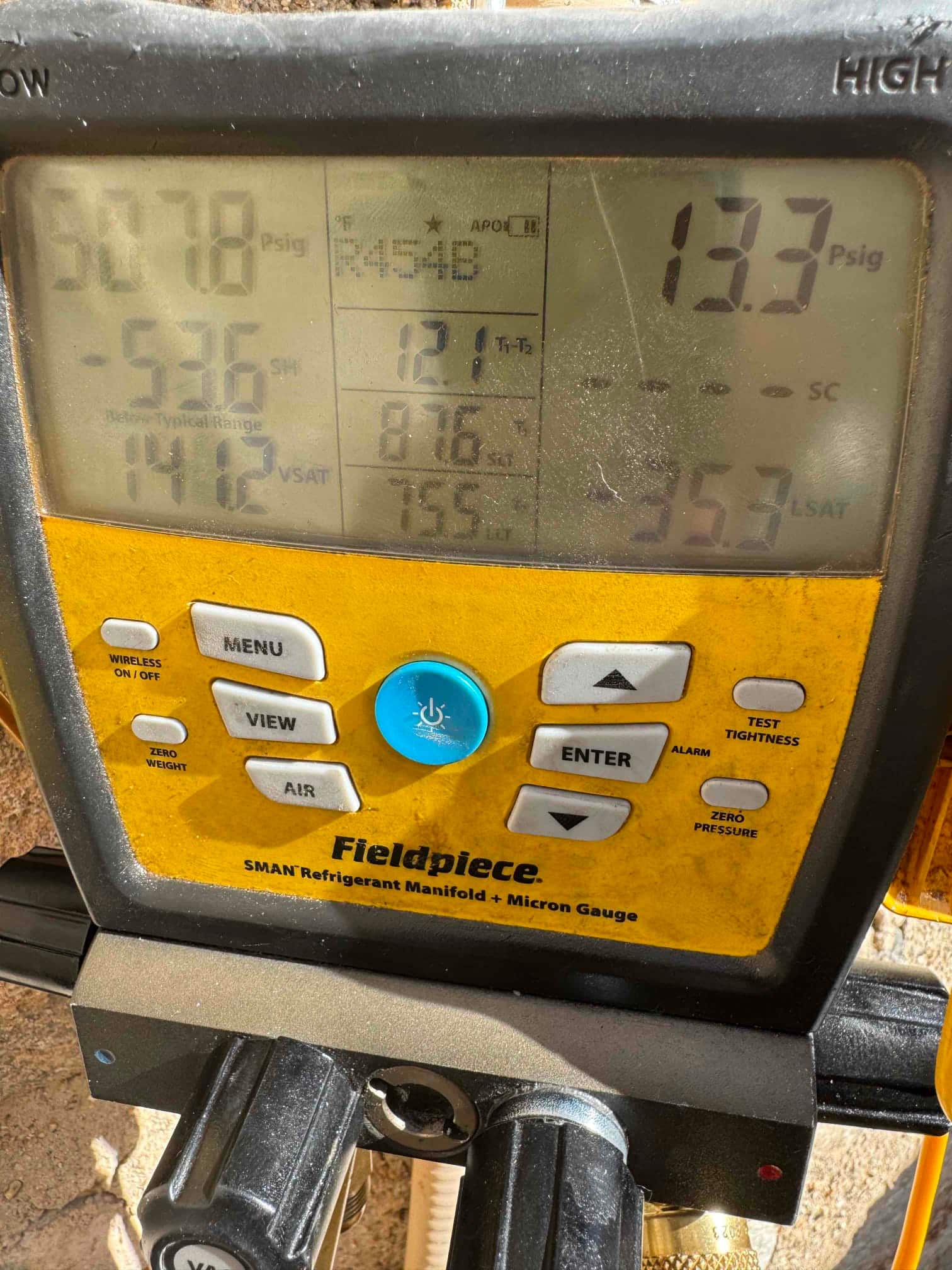 Digital manifold shows system operating pressures with refrigerant selected as R-454B during commissioning checks.