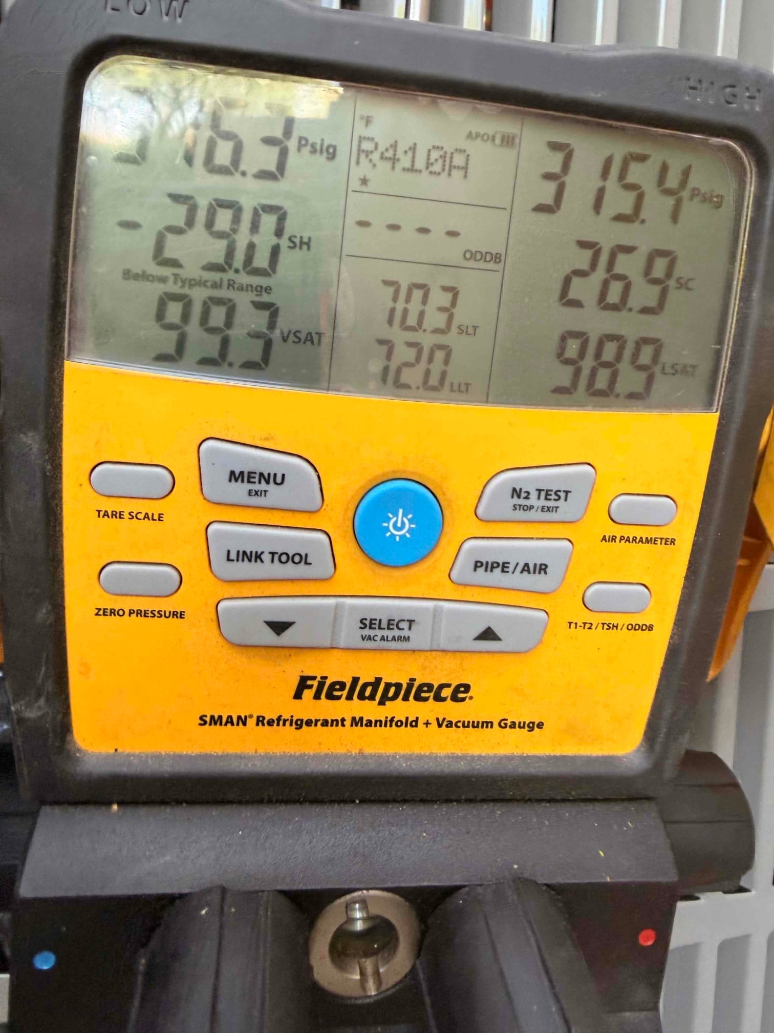 Digital manifold shows system operating pressures with superheat and subcooling while commissioning the newly installed air conditioning system.