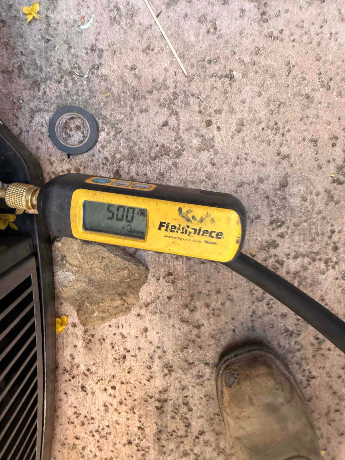 Digital micron gauge connected during evacuation shows 508 microns, confirming a deep vacuum before releasing refrigerant.