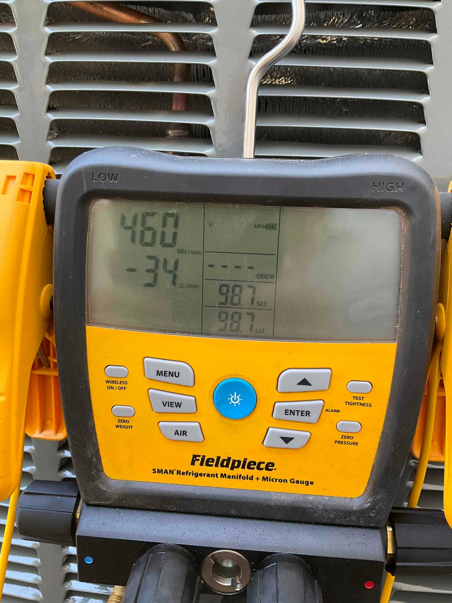 Digital micron gauge on the outdoor unit shows 460 microns during evacuation prior to refrigerant charging.
