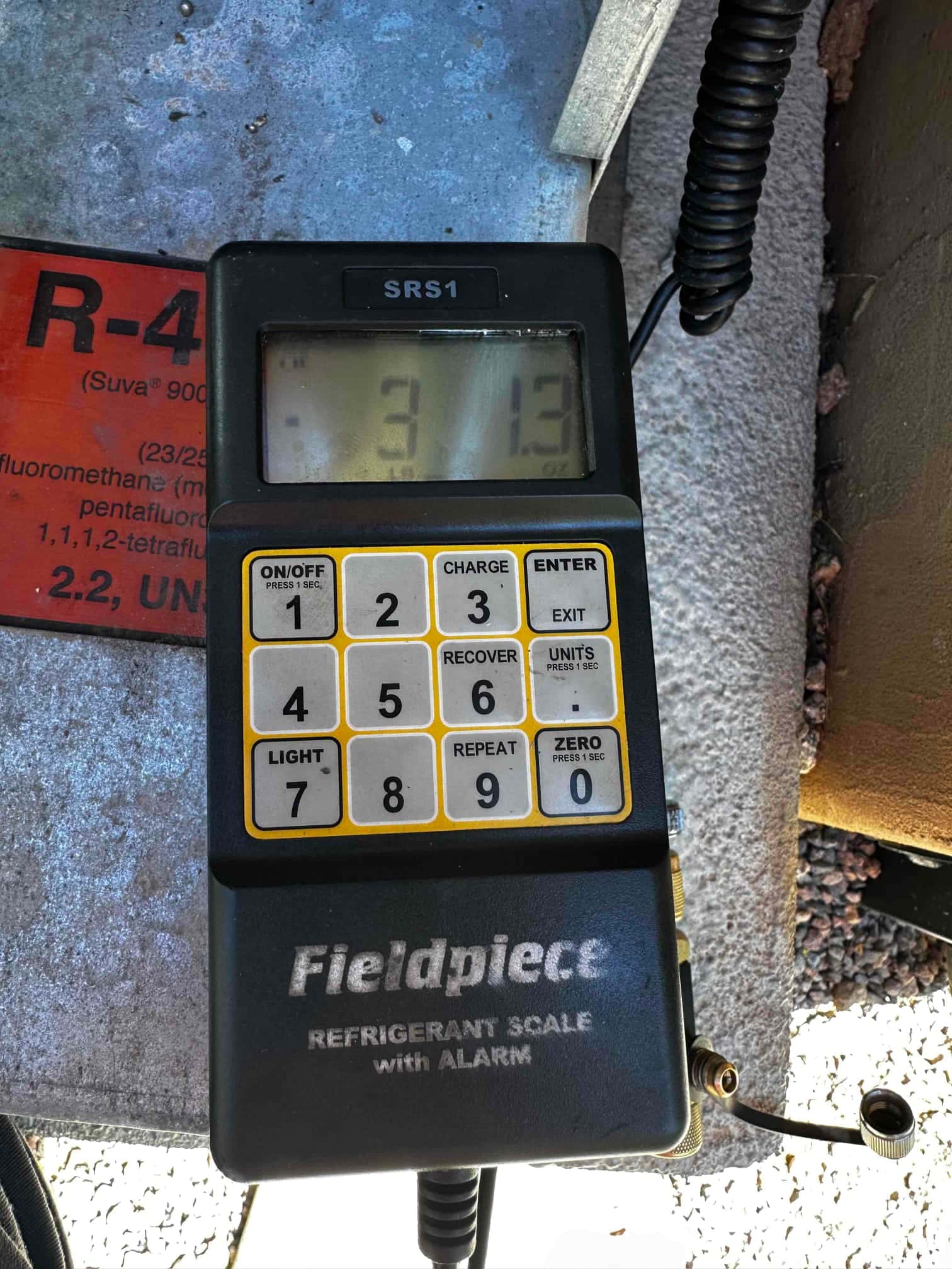 Digital refrigerant scale displays 3.13, documenting charge weight during commissioning of the installed system.