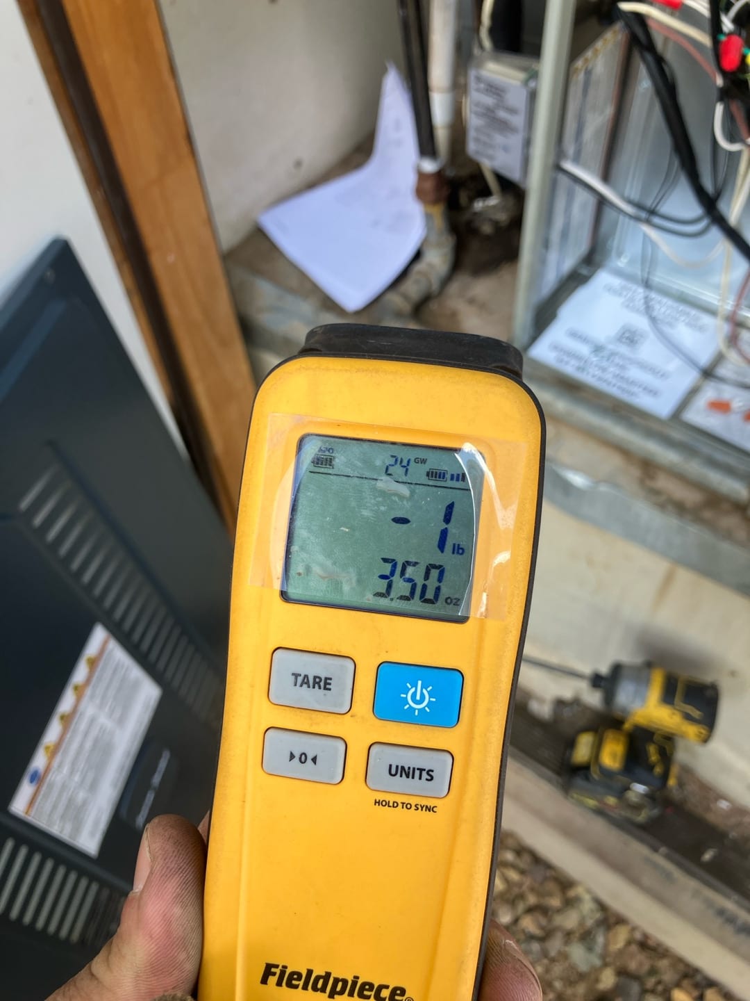 Digital refrigerant scale displays 3.50 ounces while charging the newly installed HVAC system at the indoor unit service area.