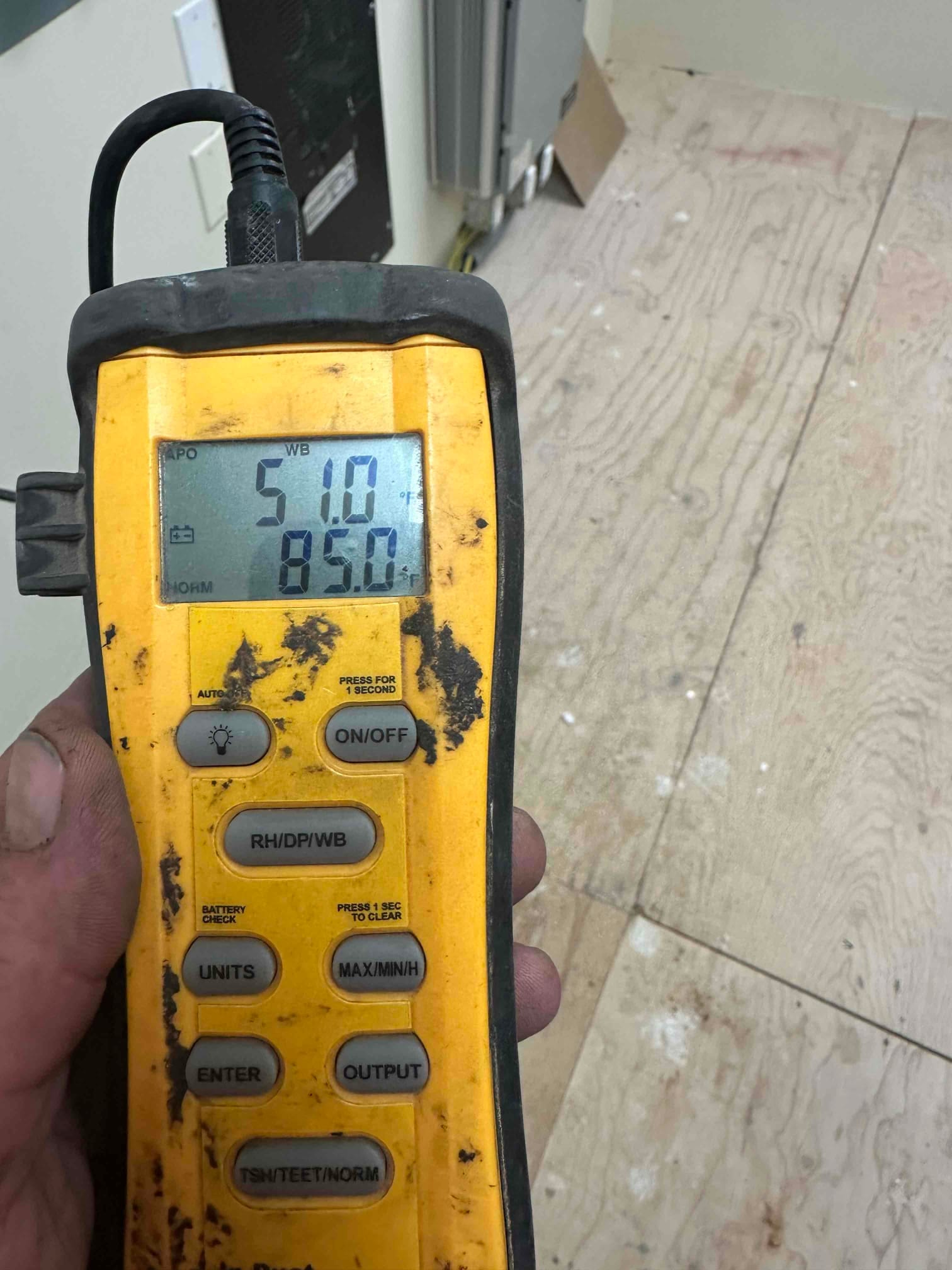Digital thermometer displays 51.0°F and 85.0°F during air temperature checks as part of system commissioning.