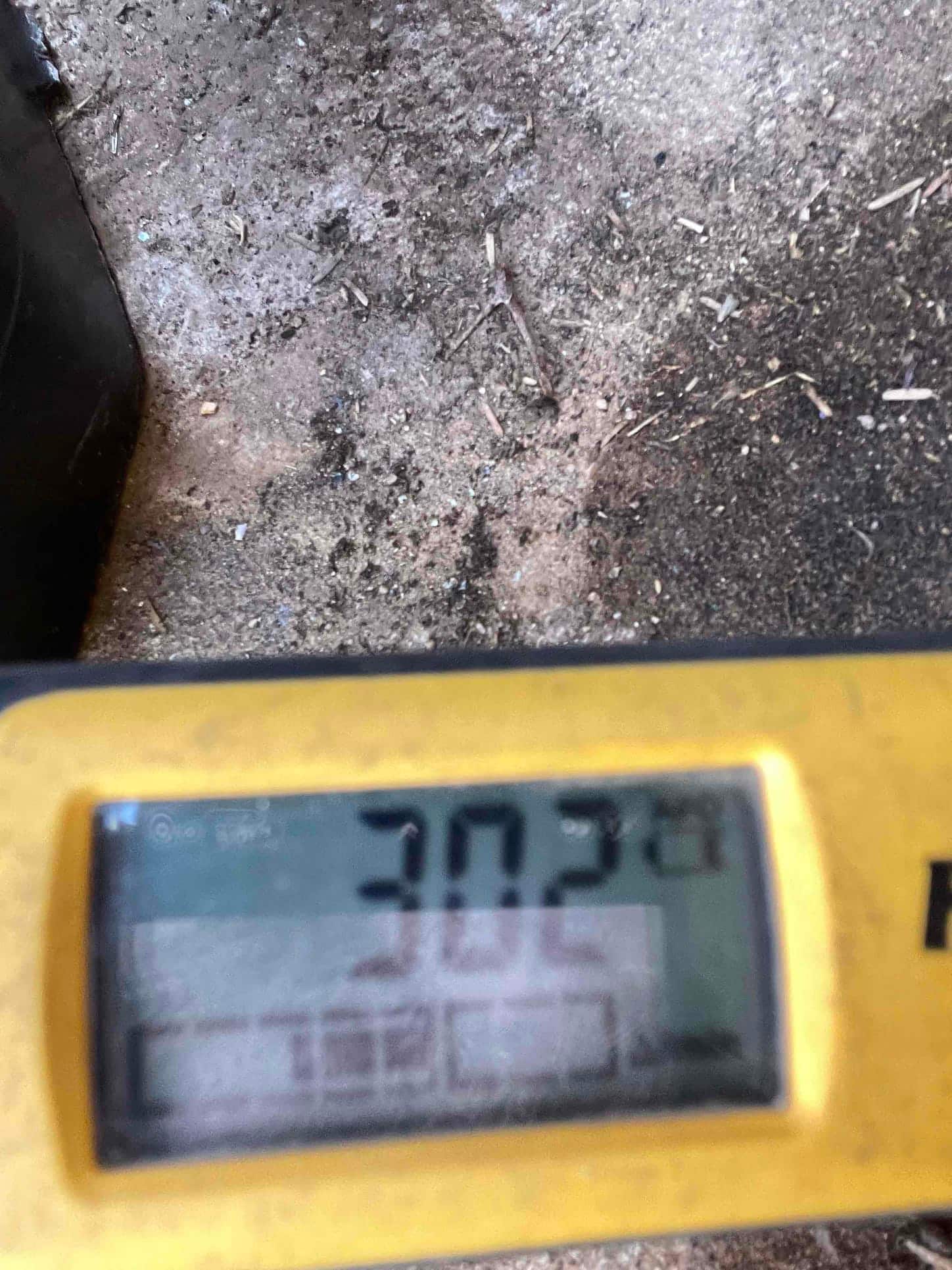 Digital thermometer shows 30.2 degrees on its display during air temperature measurement at the HVAC installation site.