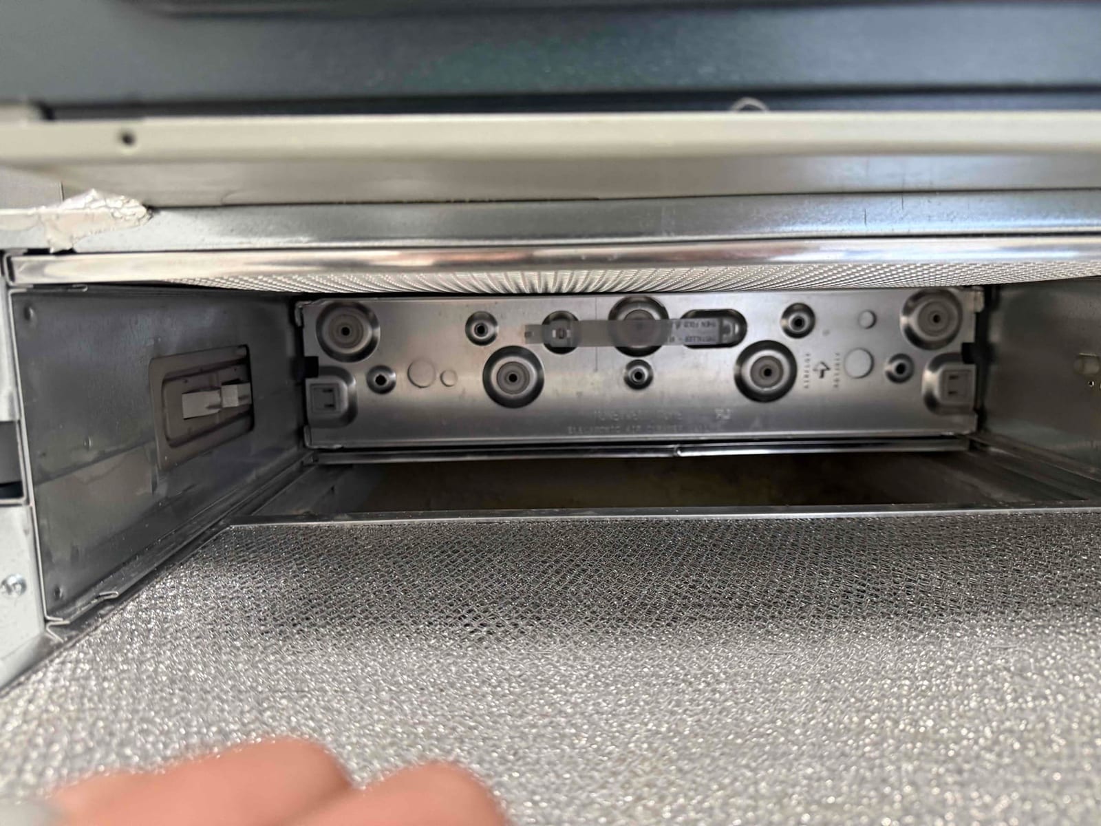 Interior view of an air handler cabinet with access panel removed, showing the blower compartment and insulated bottom panel.