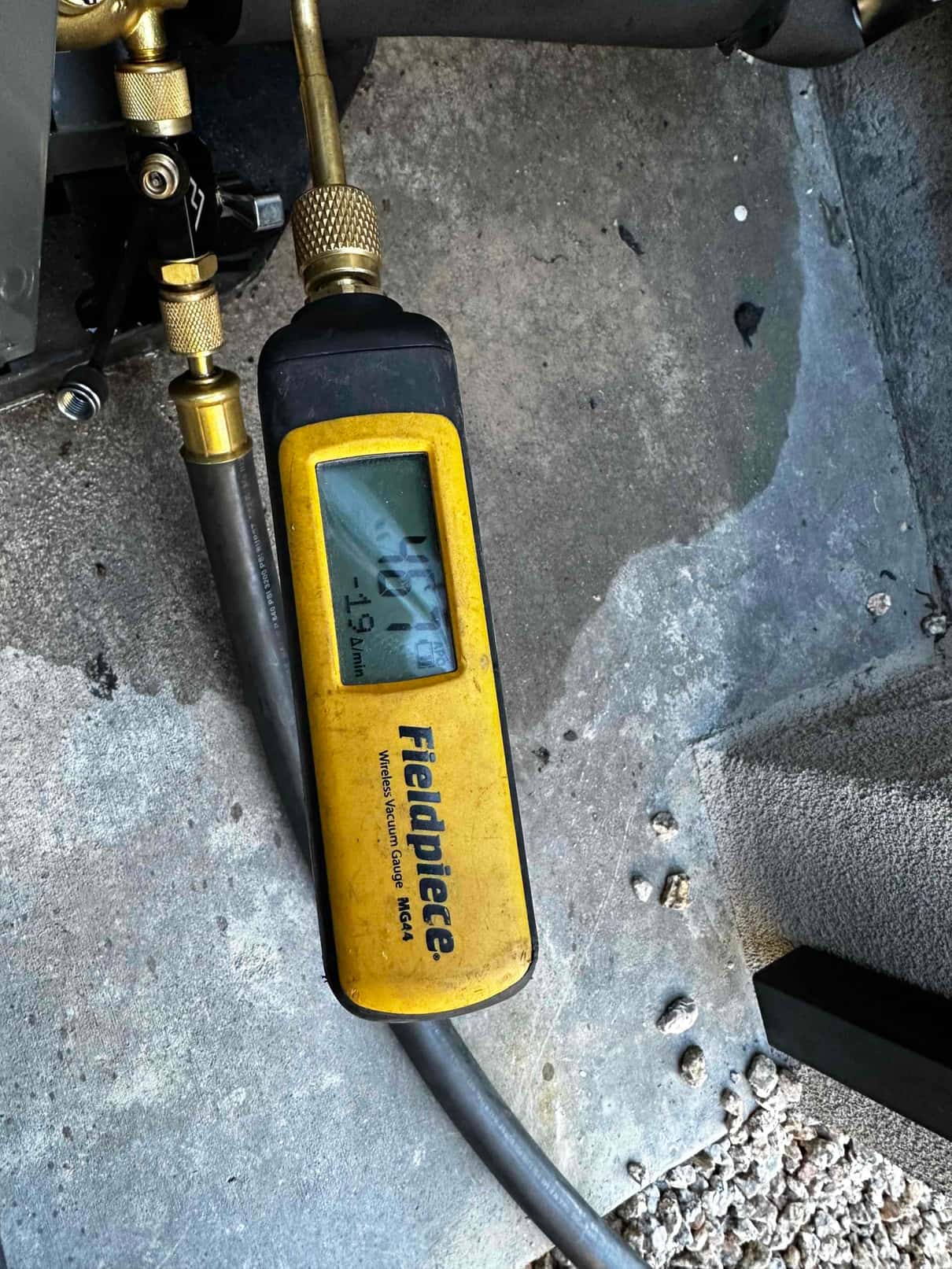 Micron gauge connected to the system shows a deep vacuum achieved during evacuation prior to refrigerant charging.