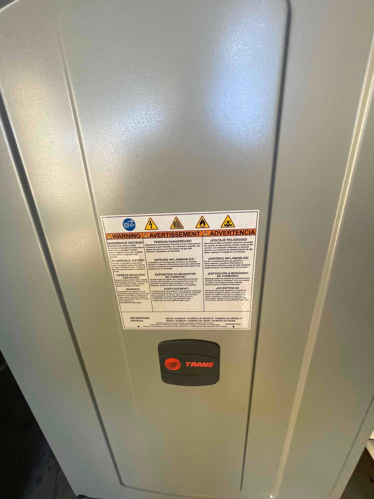 New furnace cabinet installed with front panel and safety warning label visible in the mechanical room.