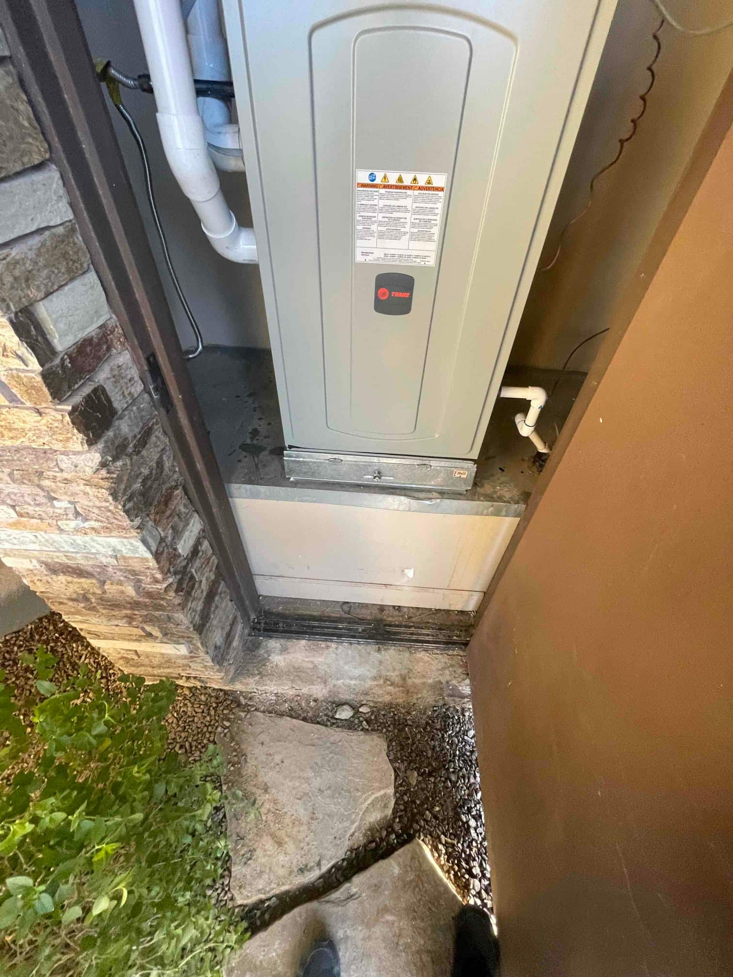 New furnace set in an exterior closet with PVC intake and exhaust piping and a routed condensate drain connection.