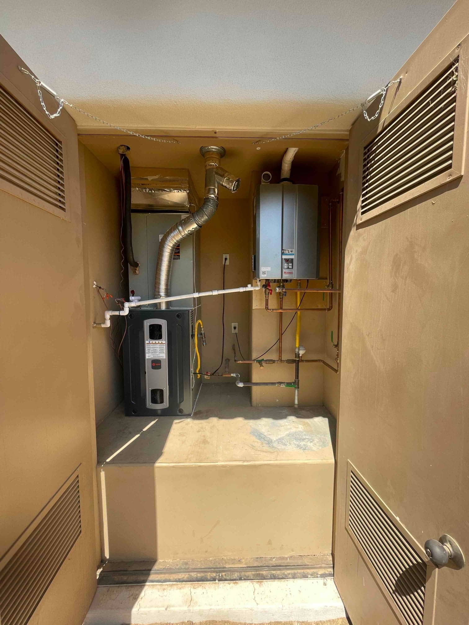 New indoor equipment installed on a platform with duct transitions, venting, gas piping, condensate drain, and service valves accessible.